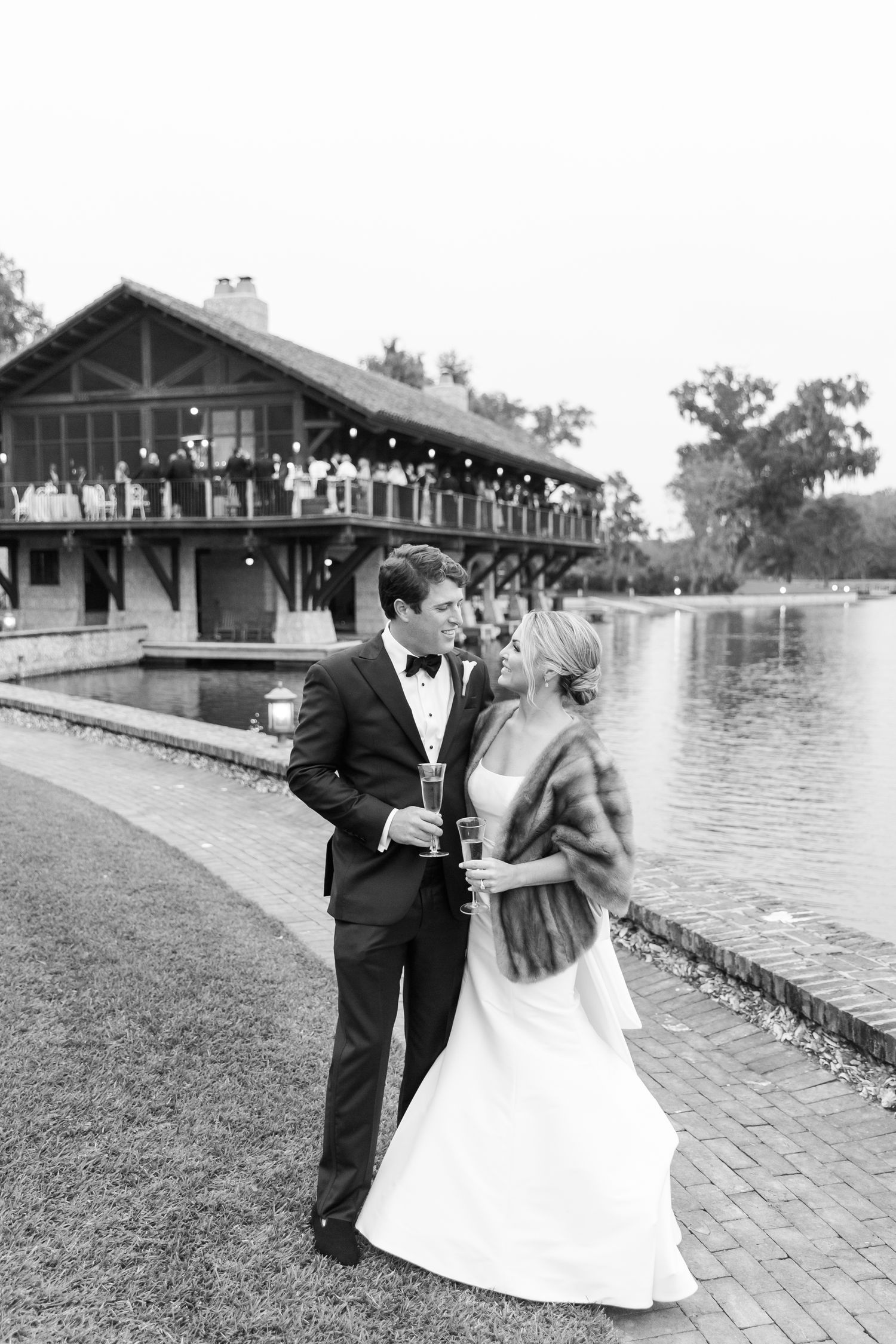 A classic black and white wedding portrait by a lakeside venue with architectural details at the Frederica Golf Club in St. Simons.
