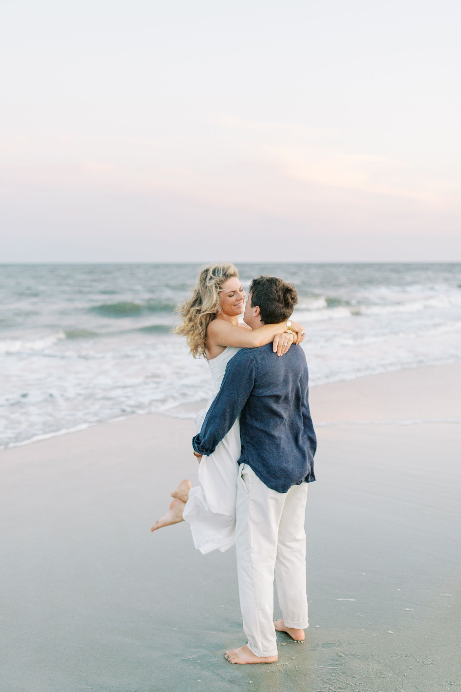 Romantic beachside embrace during sunset engagement photoshoot in St. Simons.
