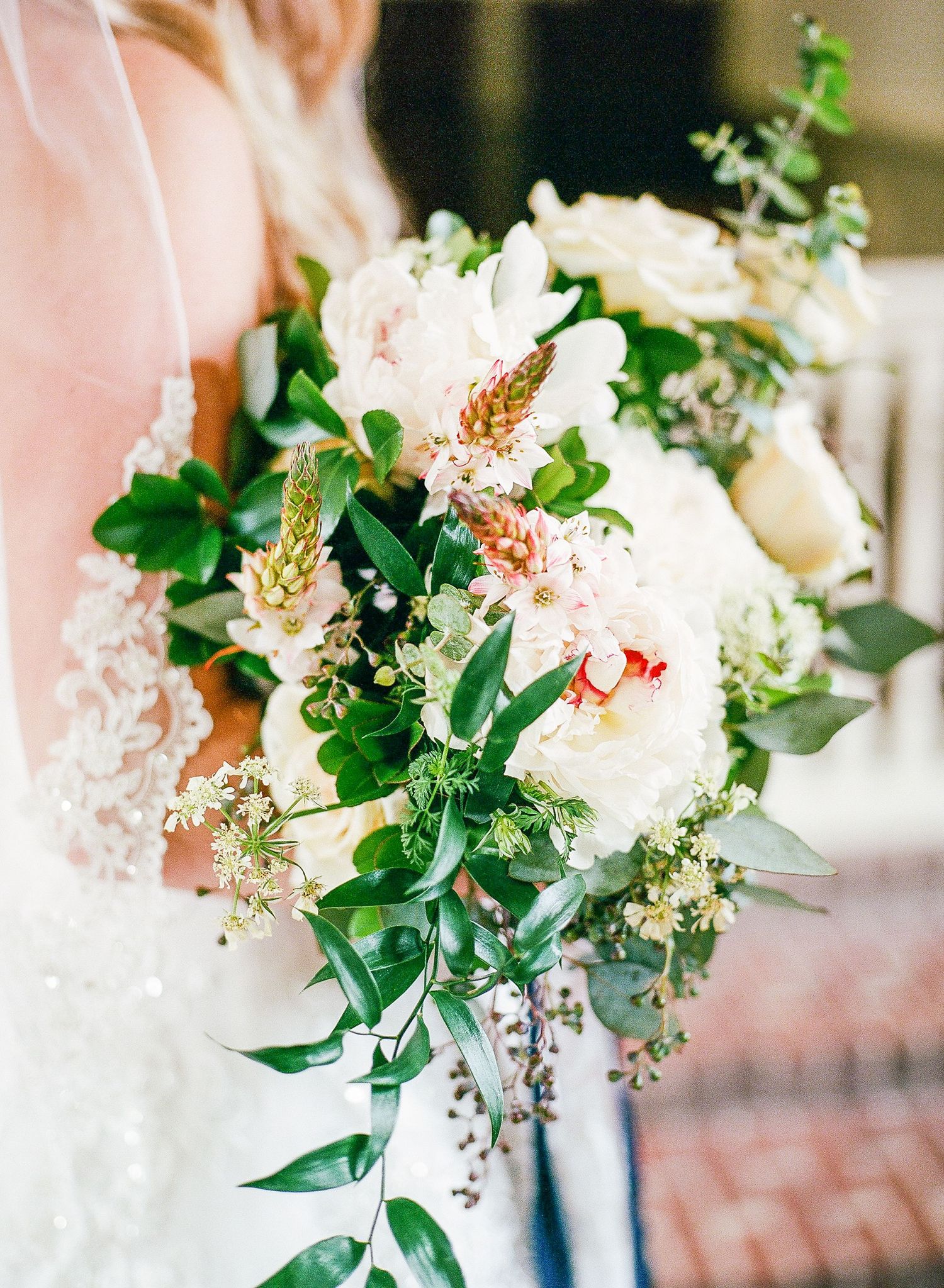 bride holding a stunning white and green bouquet