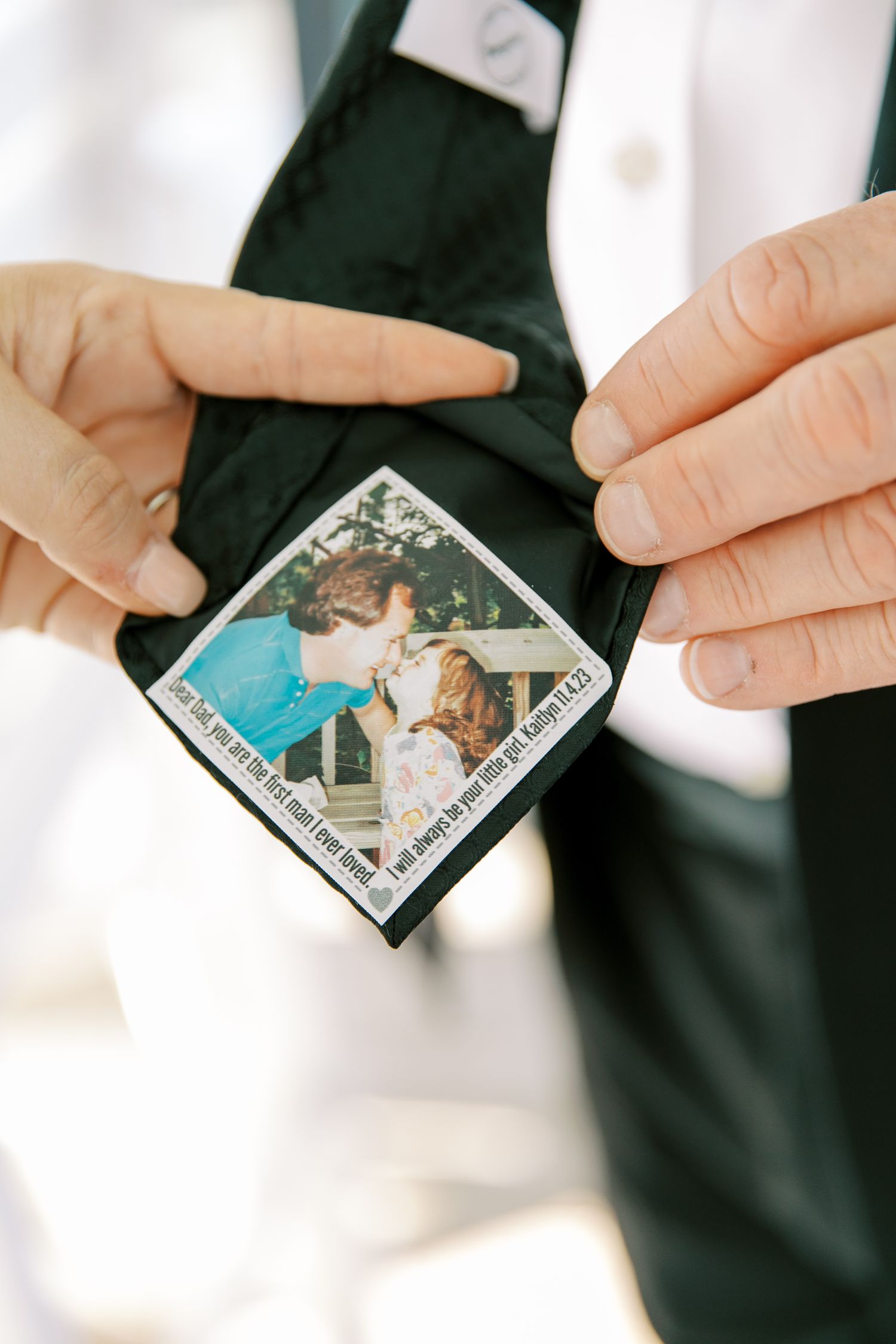 Hands holding a small vintage photograph from what appears to be a special moment or memory.