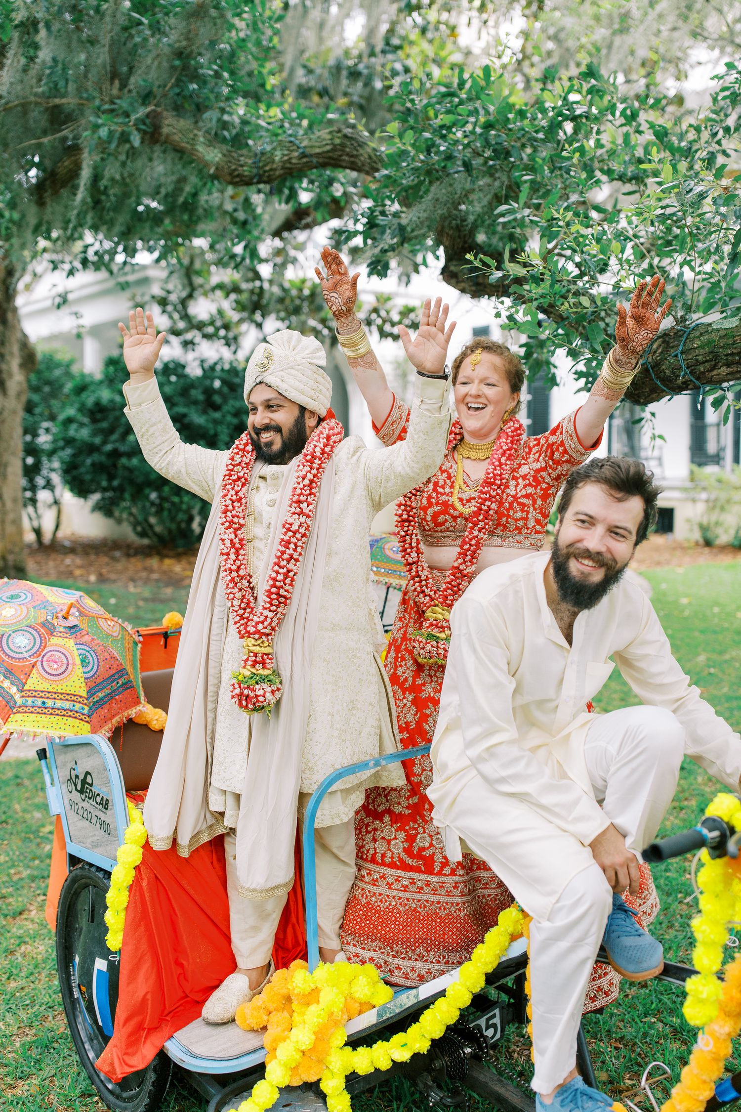 Joyful celebration with traditional Indian wedding attire and bright yellow decorations outdoors.