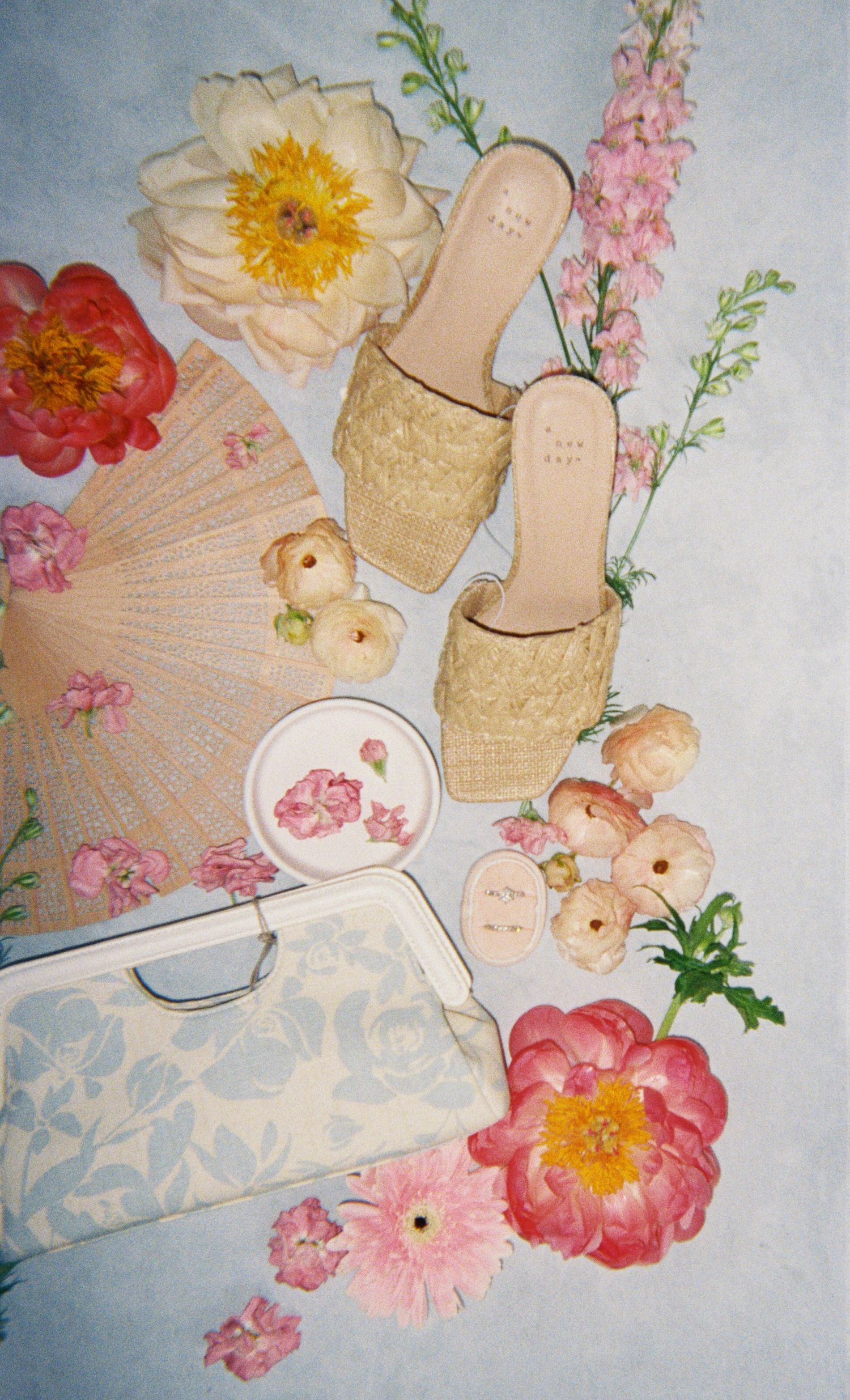 Vintage style paper crafts and floral decorations arranged with delicate pink and peach flowers on a light background.