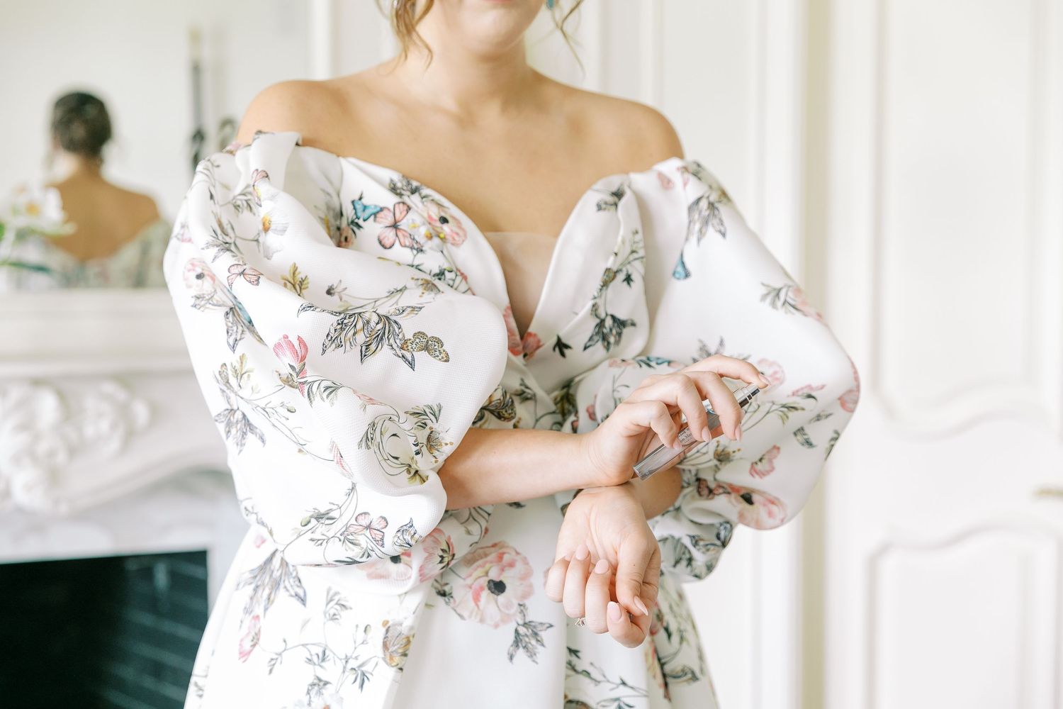 Elegant white off-shoulder dress with gray and pink floral print and romantic puff sleeves photographed in front of mirror.