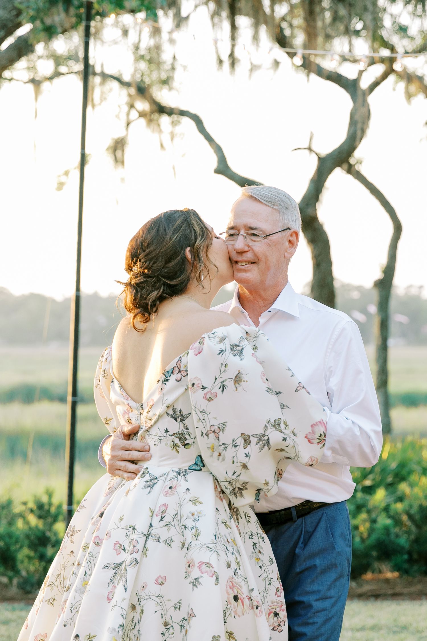 An intimate moment shared between two people during sunset under Spanish moss trees.