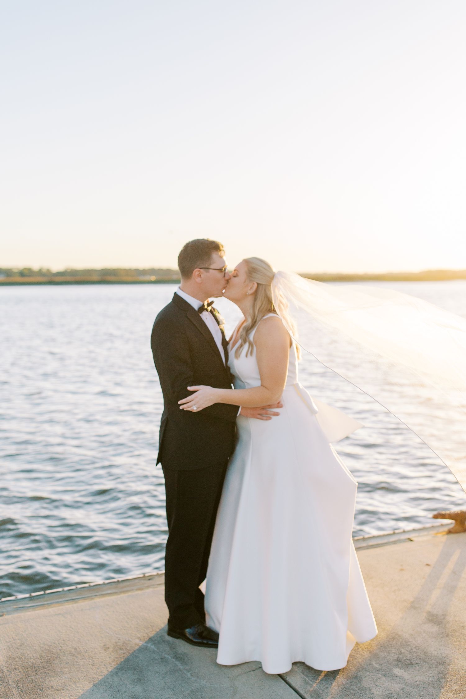 Romantic waterfront sunset moment at a coastal wedding ceremony at the Savannah Yacht Club.