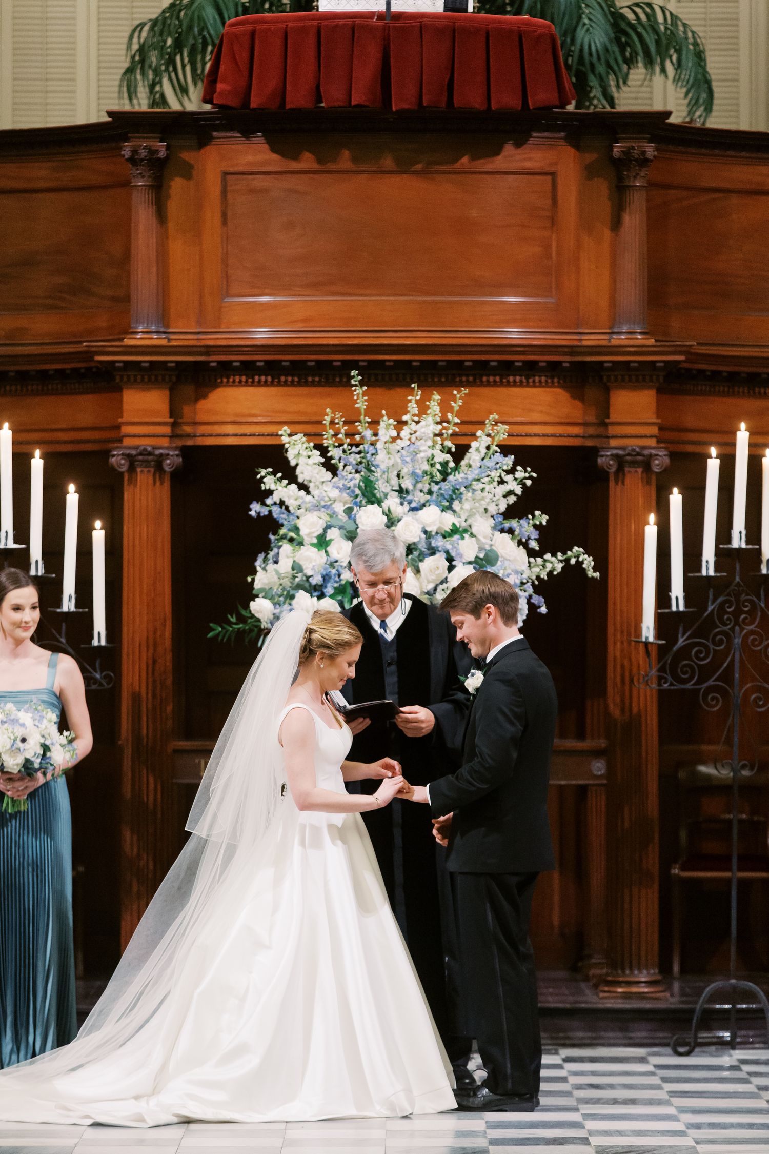 A wedding ceremony sequence showing the couple exchanging rings in an elegant wood-paneled church interior.