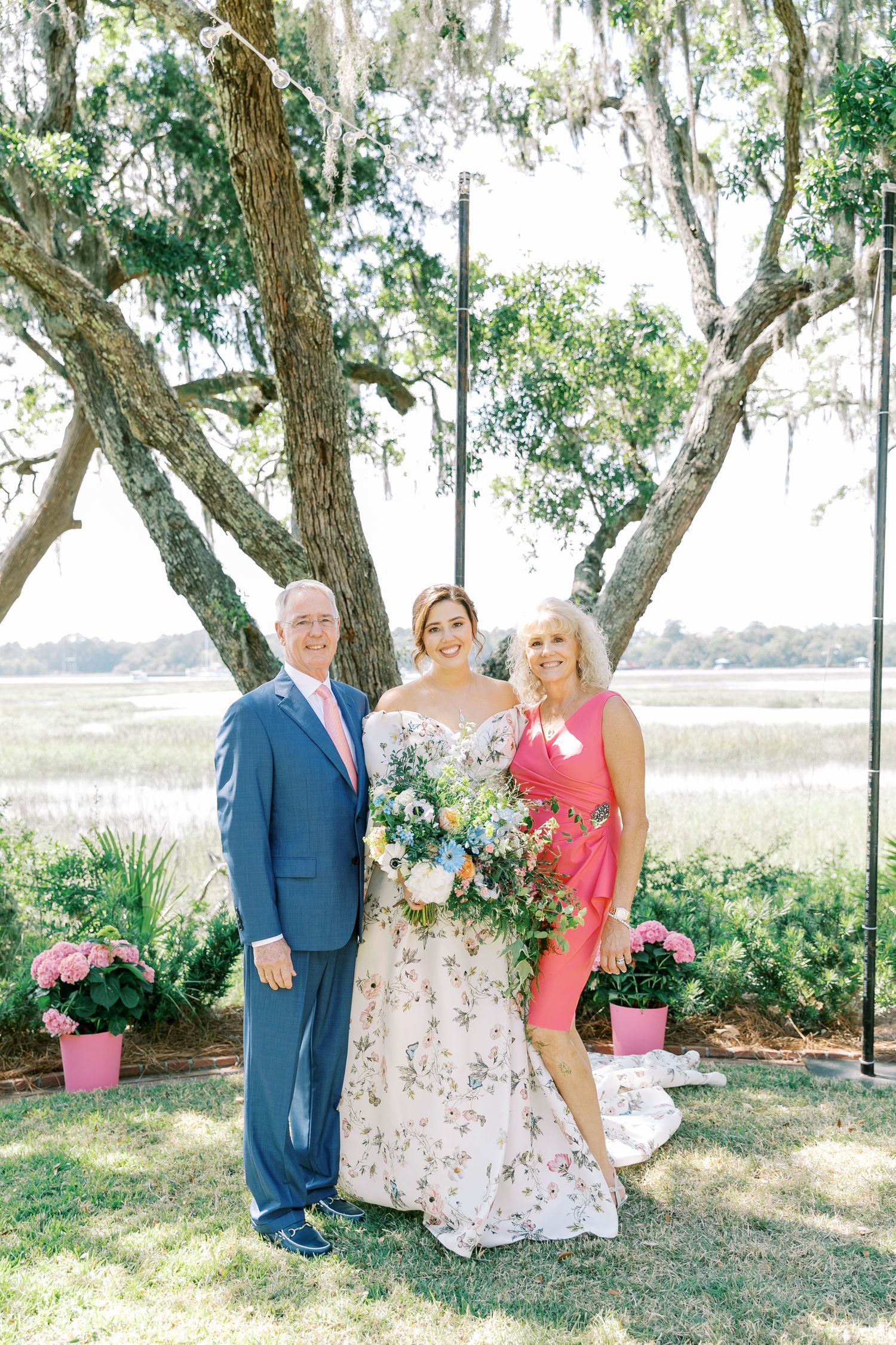 Wedding party portrait under Spanish moss trees with coastal marsh in background.
