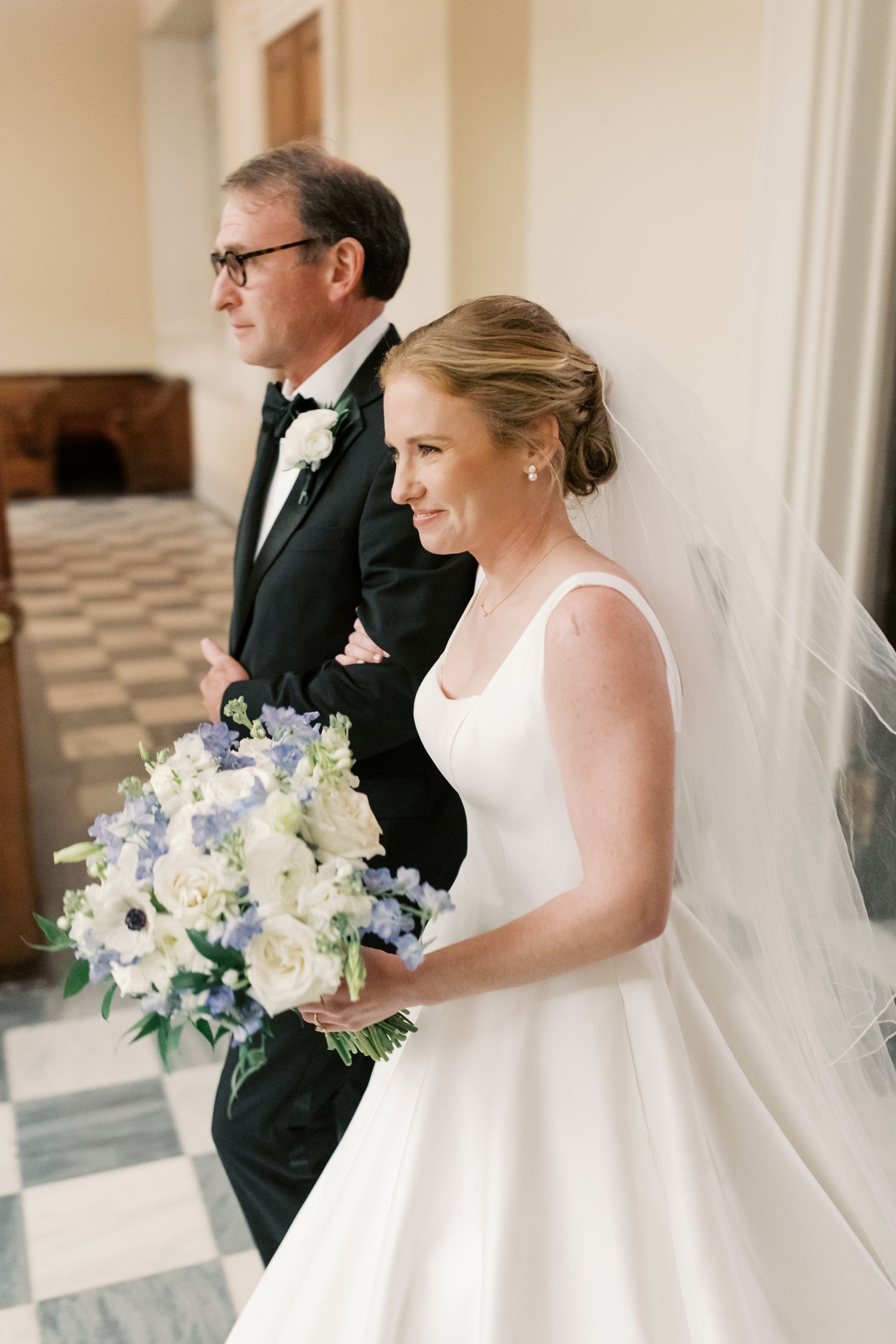 Classic wedding ceremony with white floral bouquet and elegant decor in a bright indoor venue.