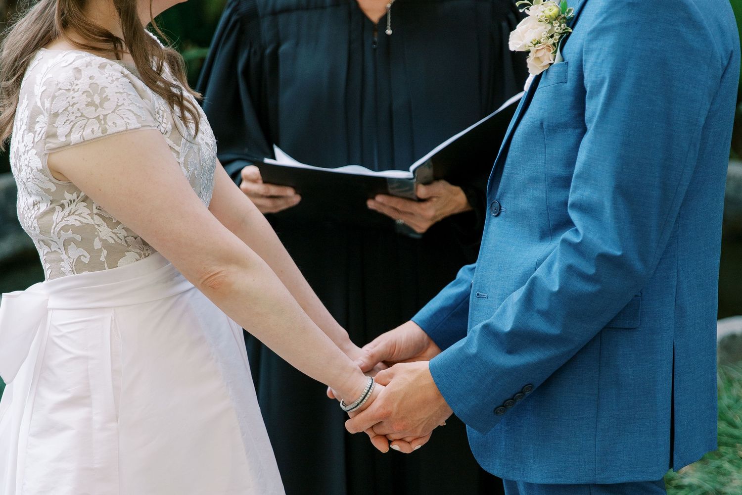 Wedding ceremony moments captured with couple exchanging vows in an outdoor garden setting.
