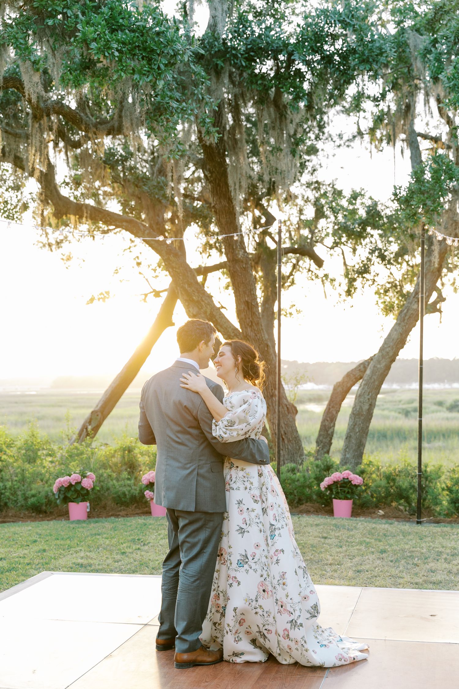 Couple shares an intimate moment under oak trees during their golden hour wedding photoshoot.