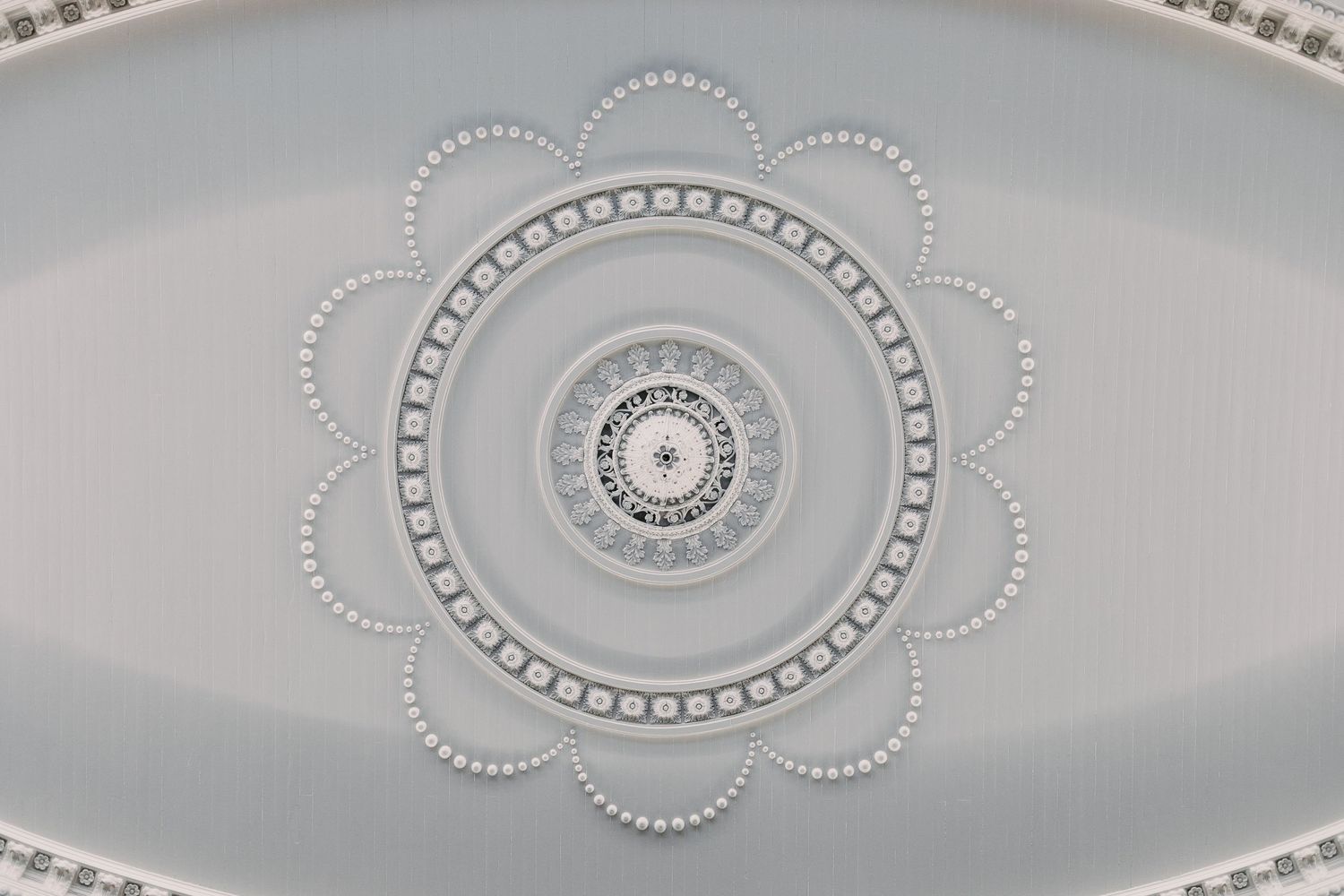 Decorative white ceiling molding detail with circular pattern.