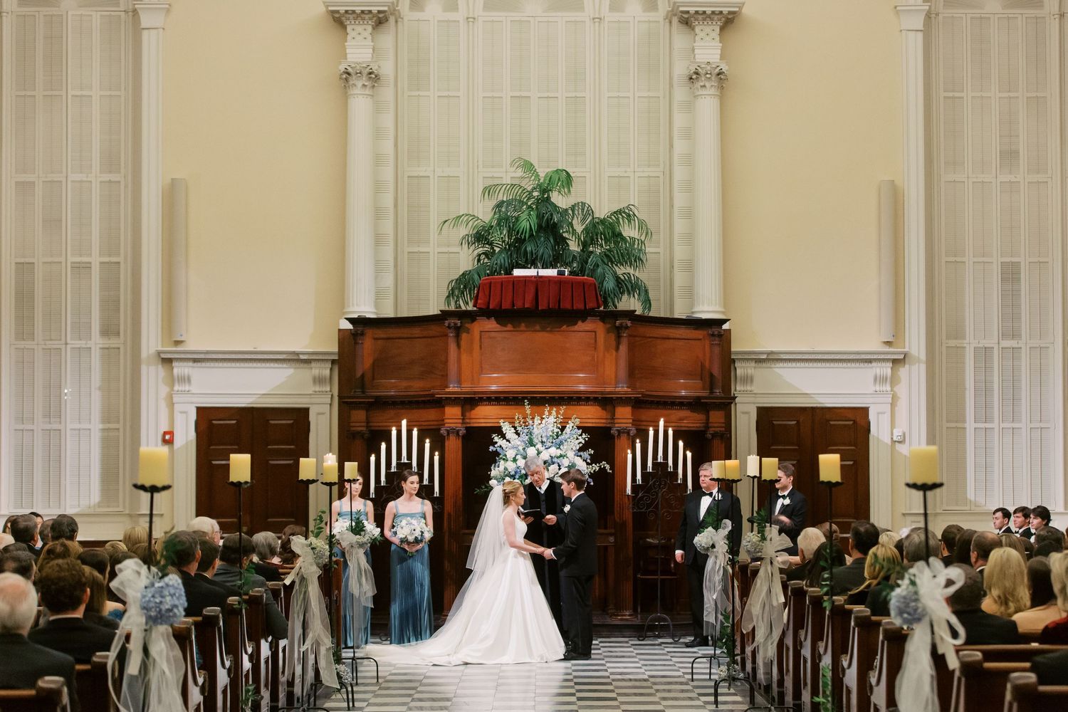 Traditional church wedding ceremony setup with wooden pews and altar decorations.