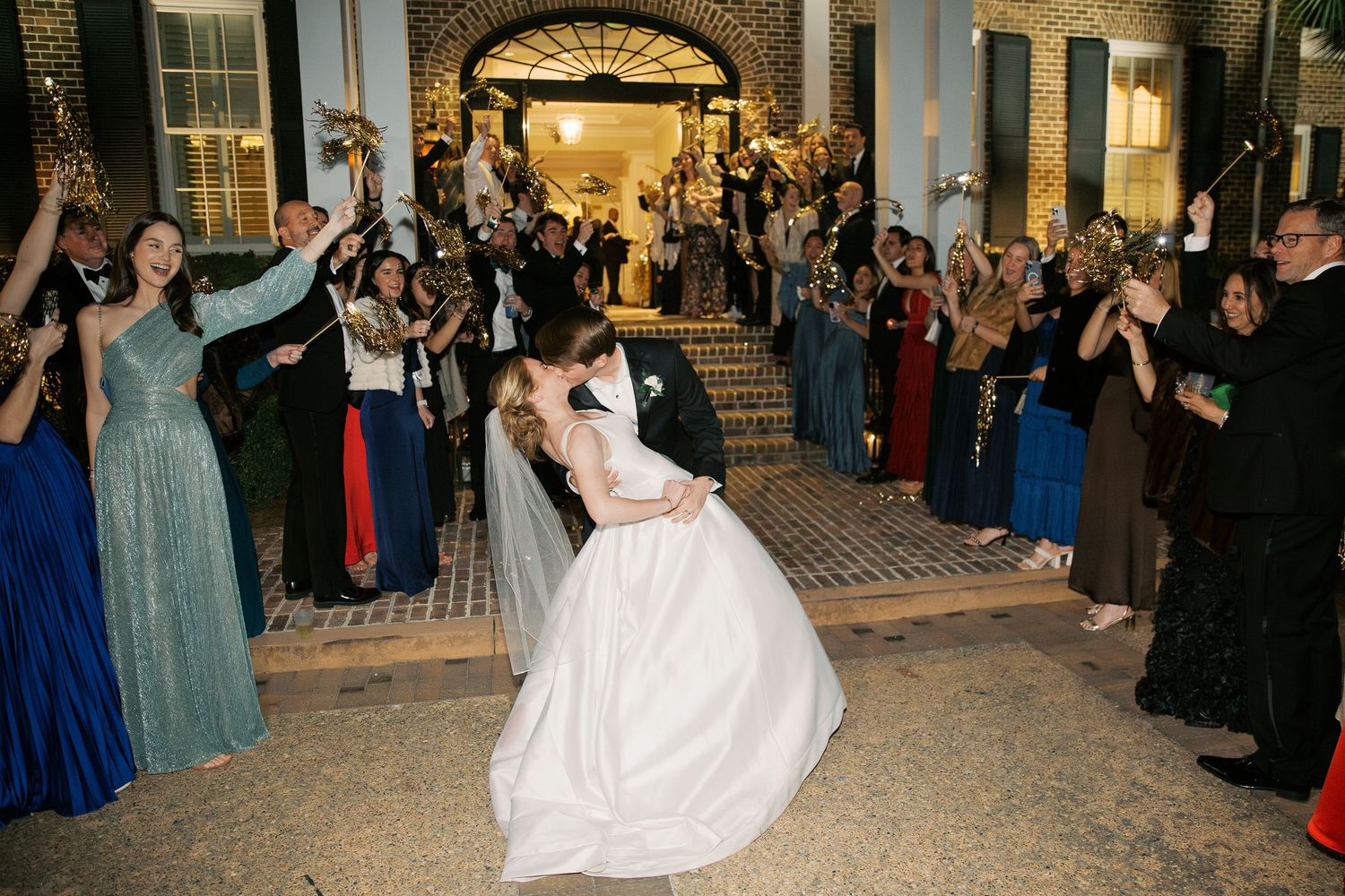 Wedding reception dance floor celebration with guests cheering.