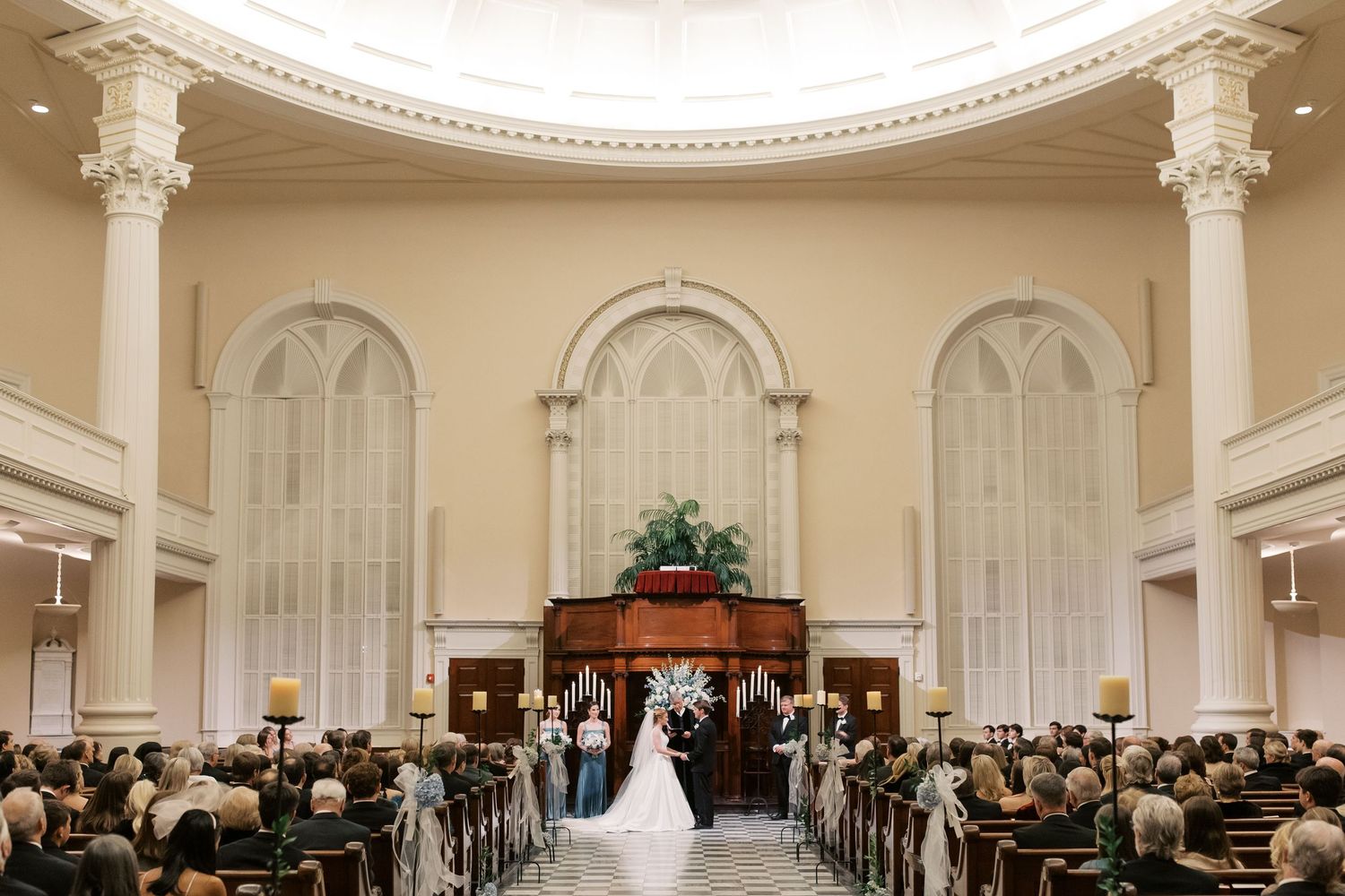 Elegant wedding ceremony venue with ornate white ceiling and columns.