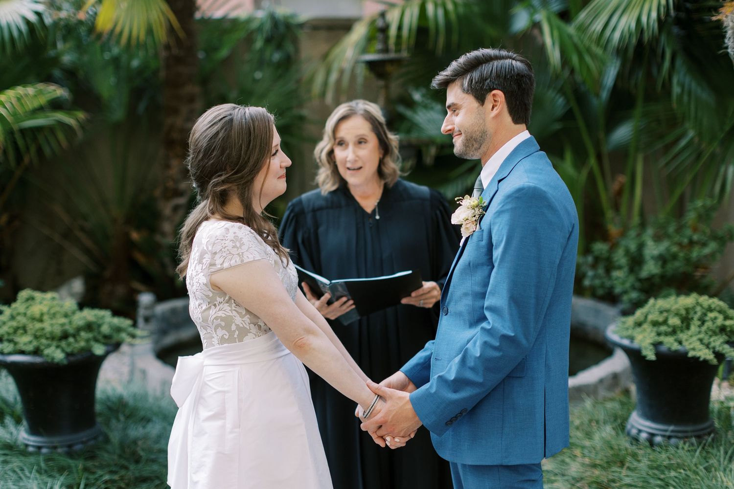 Wedding ceremony moments captured in a tropical garden setting with elegant white floral arrangements.