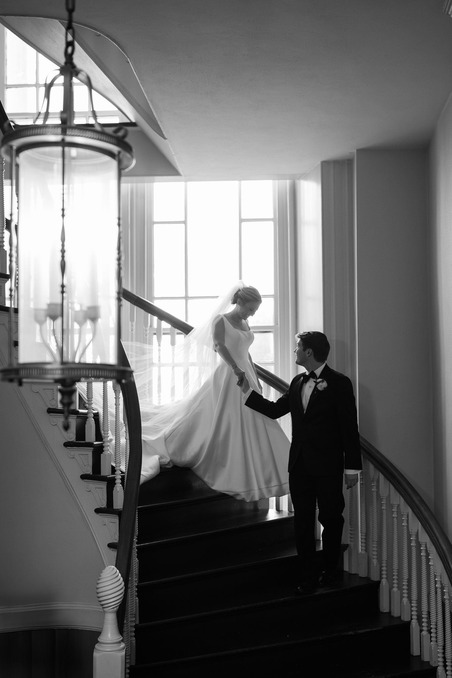 Black and white wedding photos capture silhouettes of couple on a dramatic staircase.