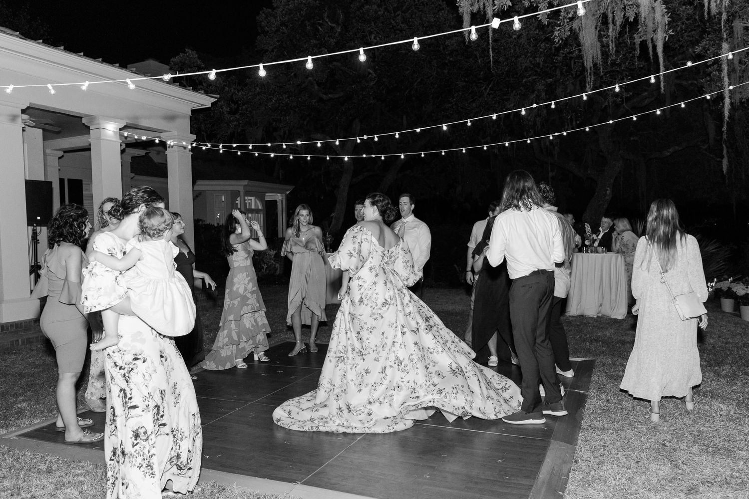 Black and white photos capture reception guests dancing under twinkling string lights at an outdoor evening wedding celebration.
