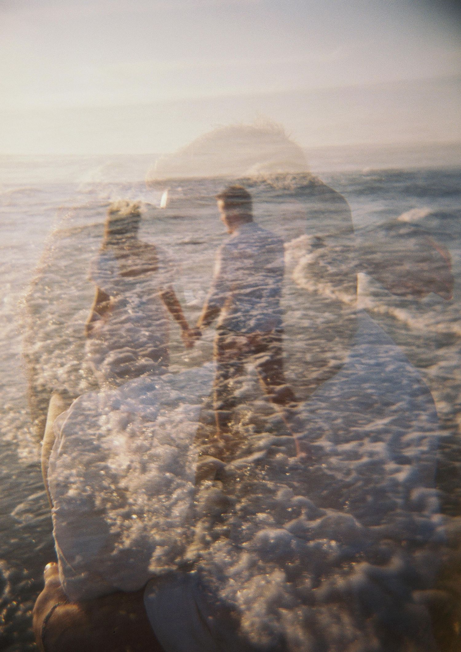 Double exposure photograph combining ocean waves with a romantic beach scene at sunset.