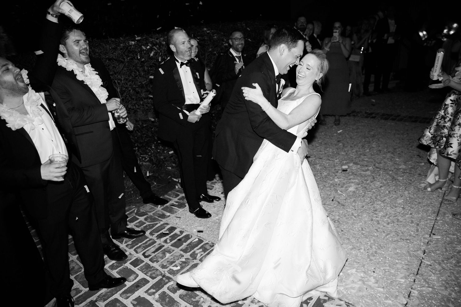Black and white photo of couple dancing during evening wedding reception.