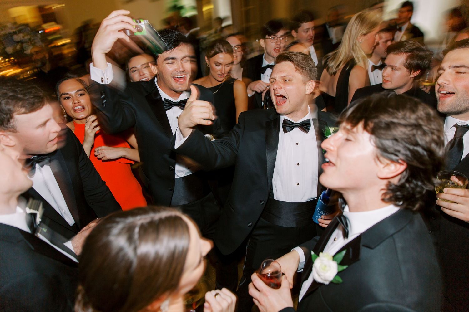 Reception celebration with formal-dressed guests in animated conversation.
