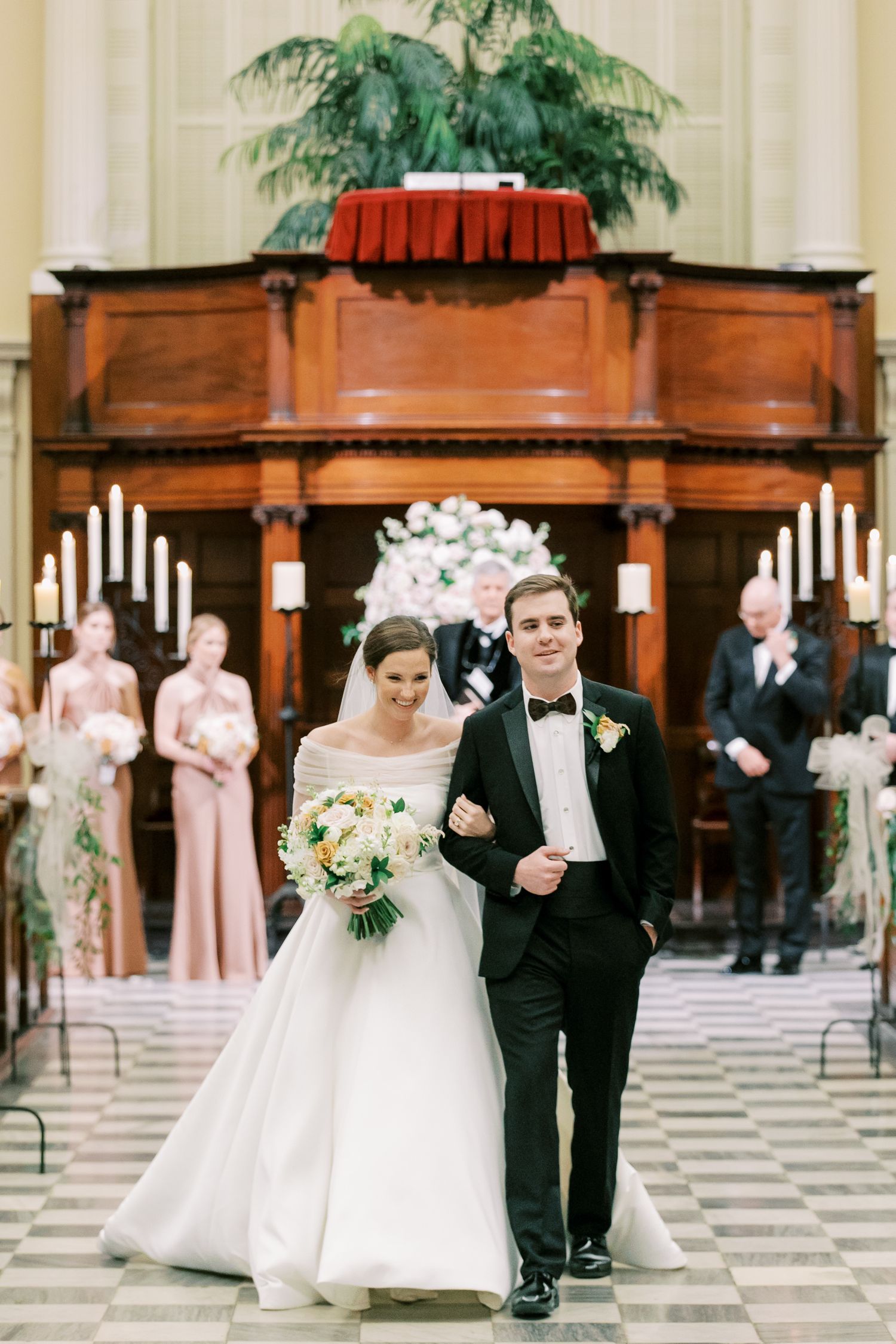 A traditional church wedding ceremony with pink-clad attendants and wooden organ pipes in the background at Independent Presbyterian Church.