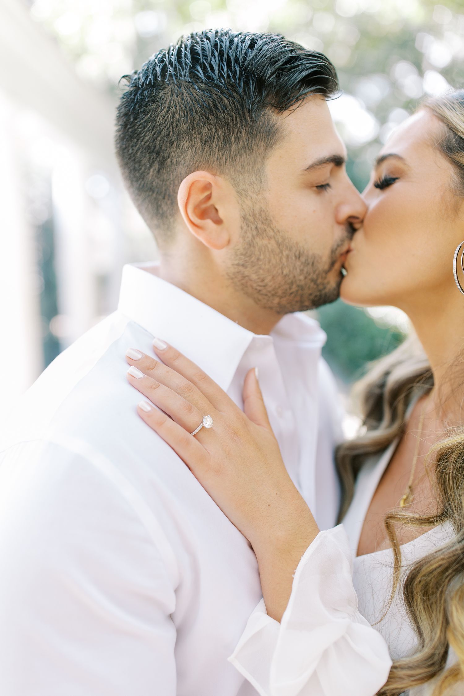 Romantic engagement photo showing ring and intimate moment.
