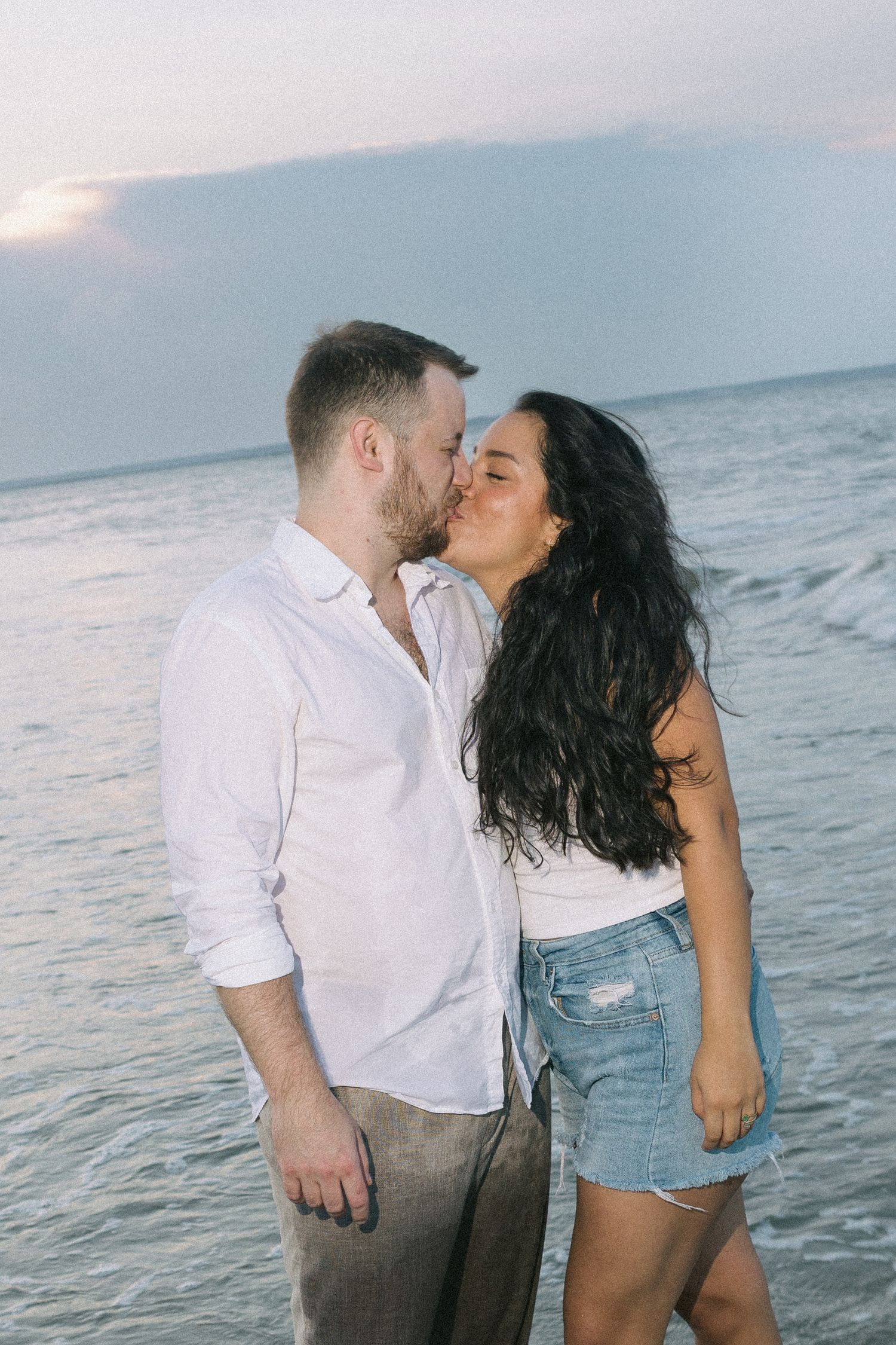 Intimate beachside moments captured in a series of casual romantic photos by the ocean.