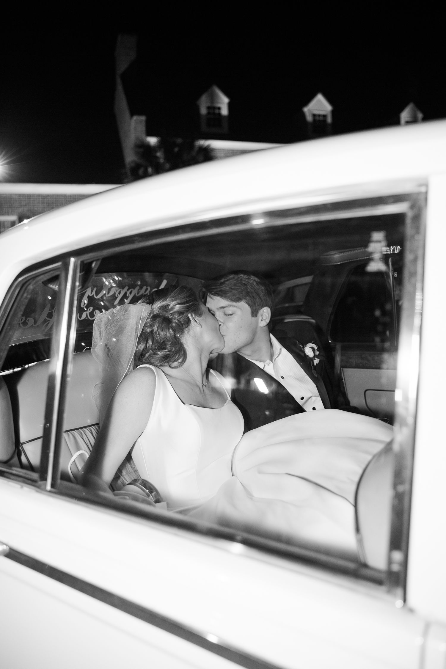 Romantic moment in classic white vintage car after wedding ceremony.