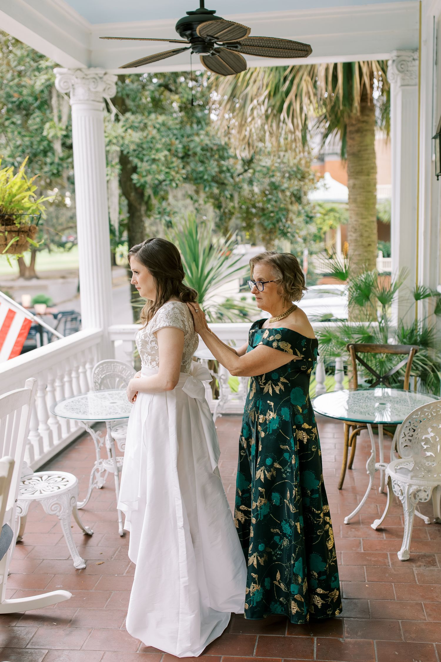A wedding preparation scene on a Southern-style porch with white columns and palm trees.