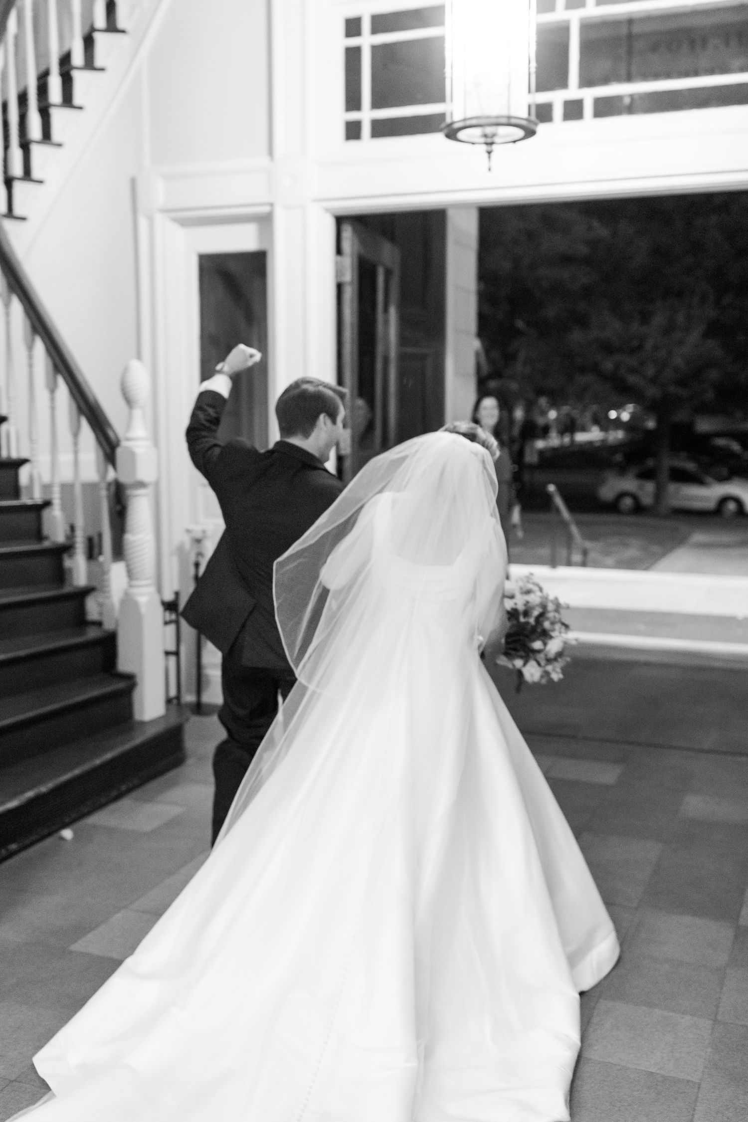 Series of candid wedding moments captured in black and white outside a grand building entrance.