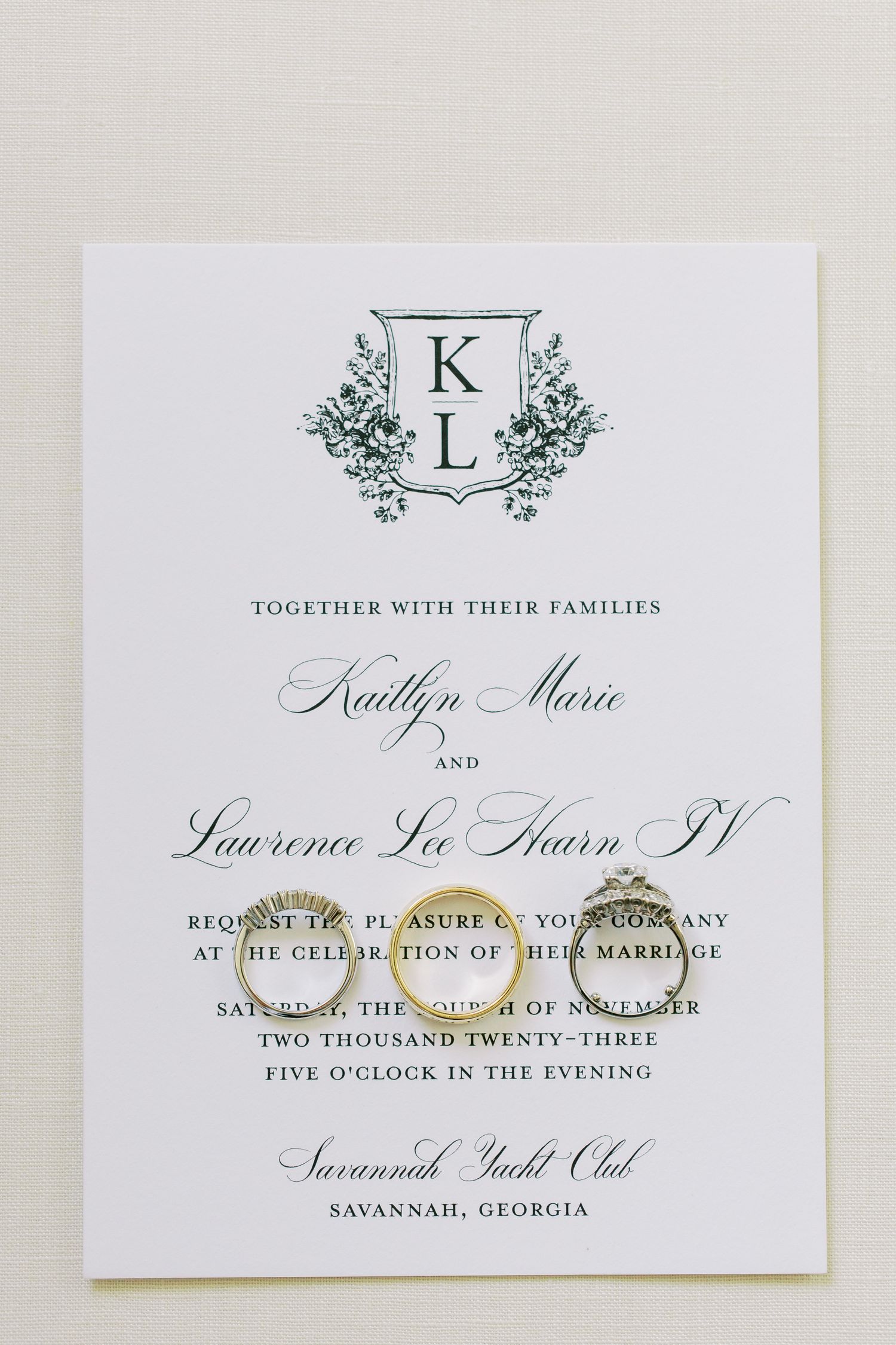 Elegant monogrammed wedding invitation with KL initials in ornate design for a ceremony at Savannah Yacht Club.