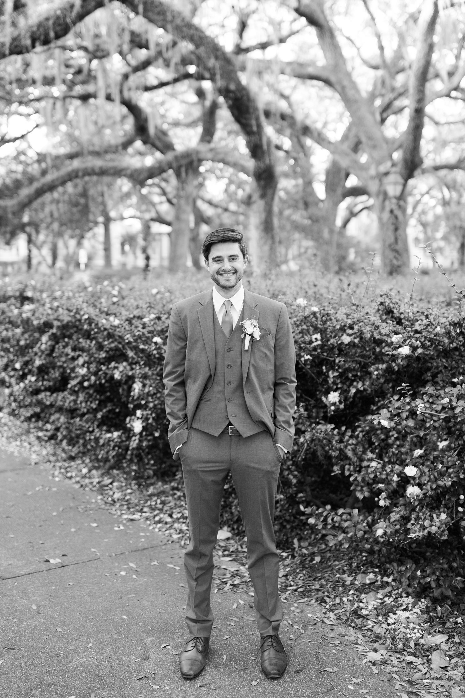 Black and white photos of a person in formal attire sitting on garden steps surrounded by oak trees.