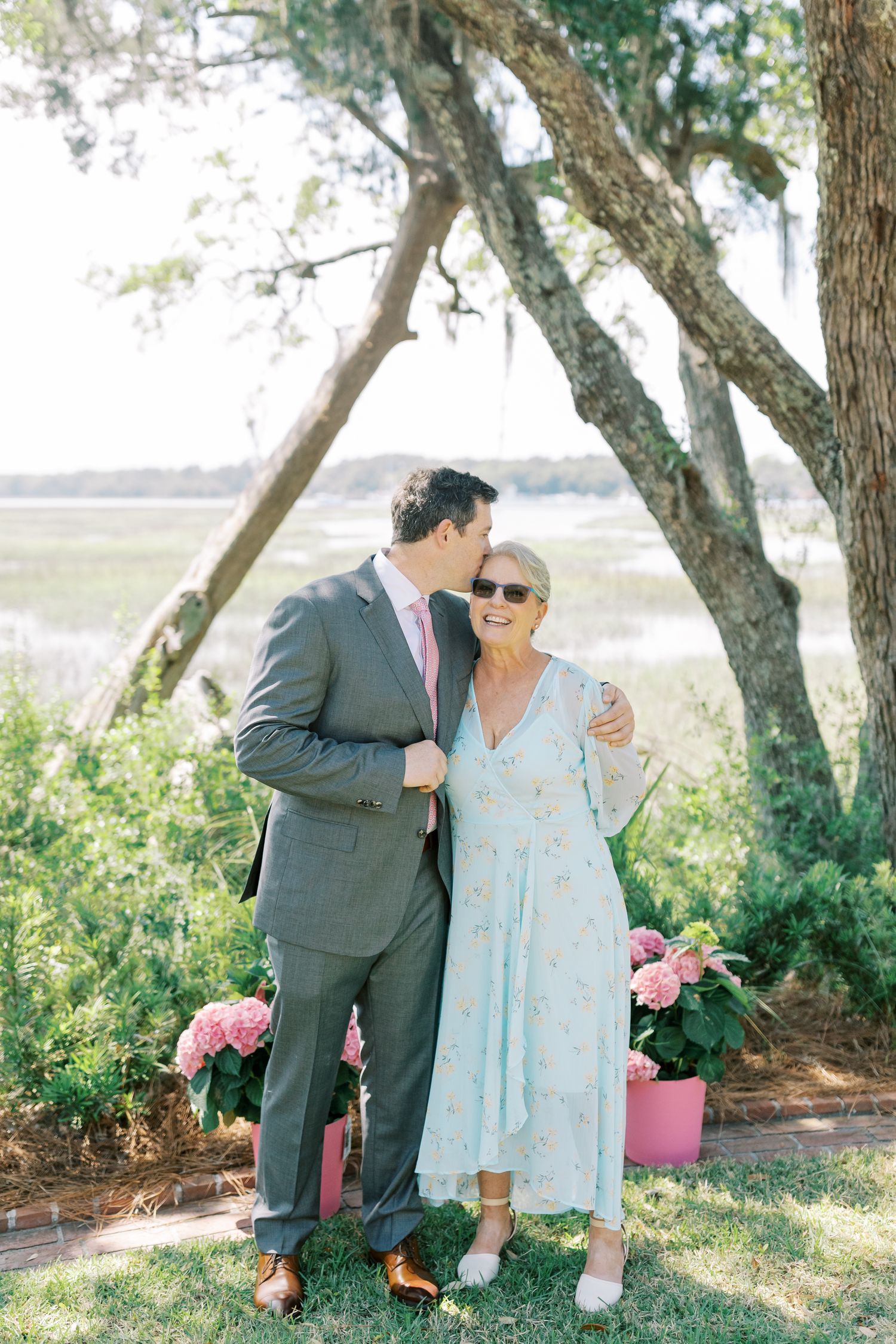 Candid moments shared between two people in a garden setting with pink floral accents.