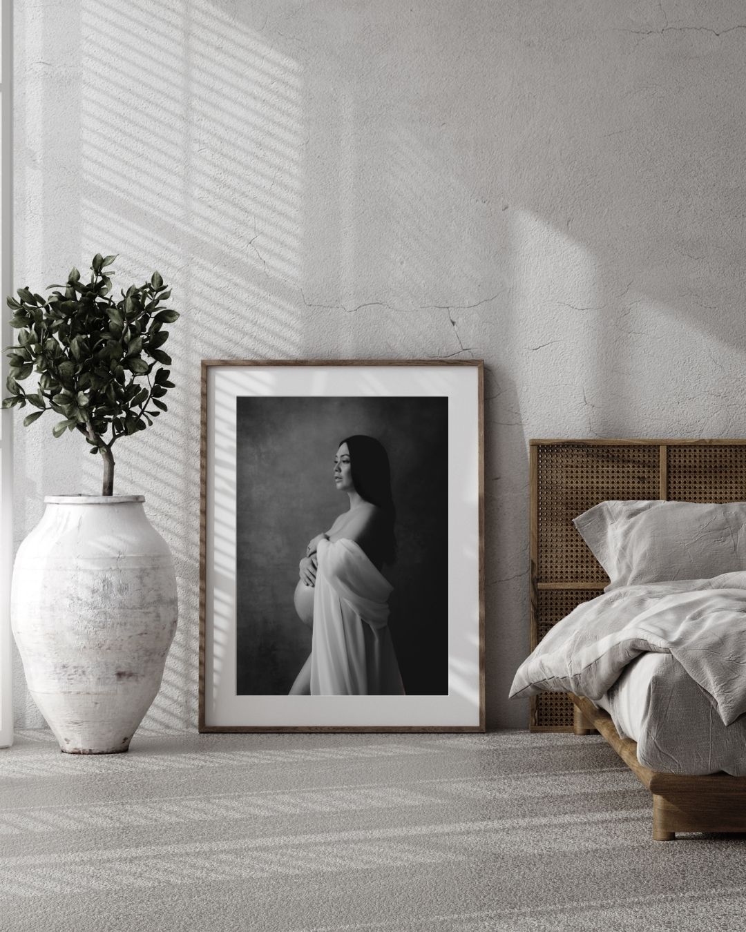 Modern sovrumsinredning med inramat svartvitt elegant gravidporträtt tagen i studio.