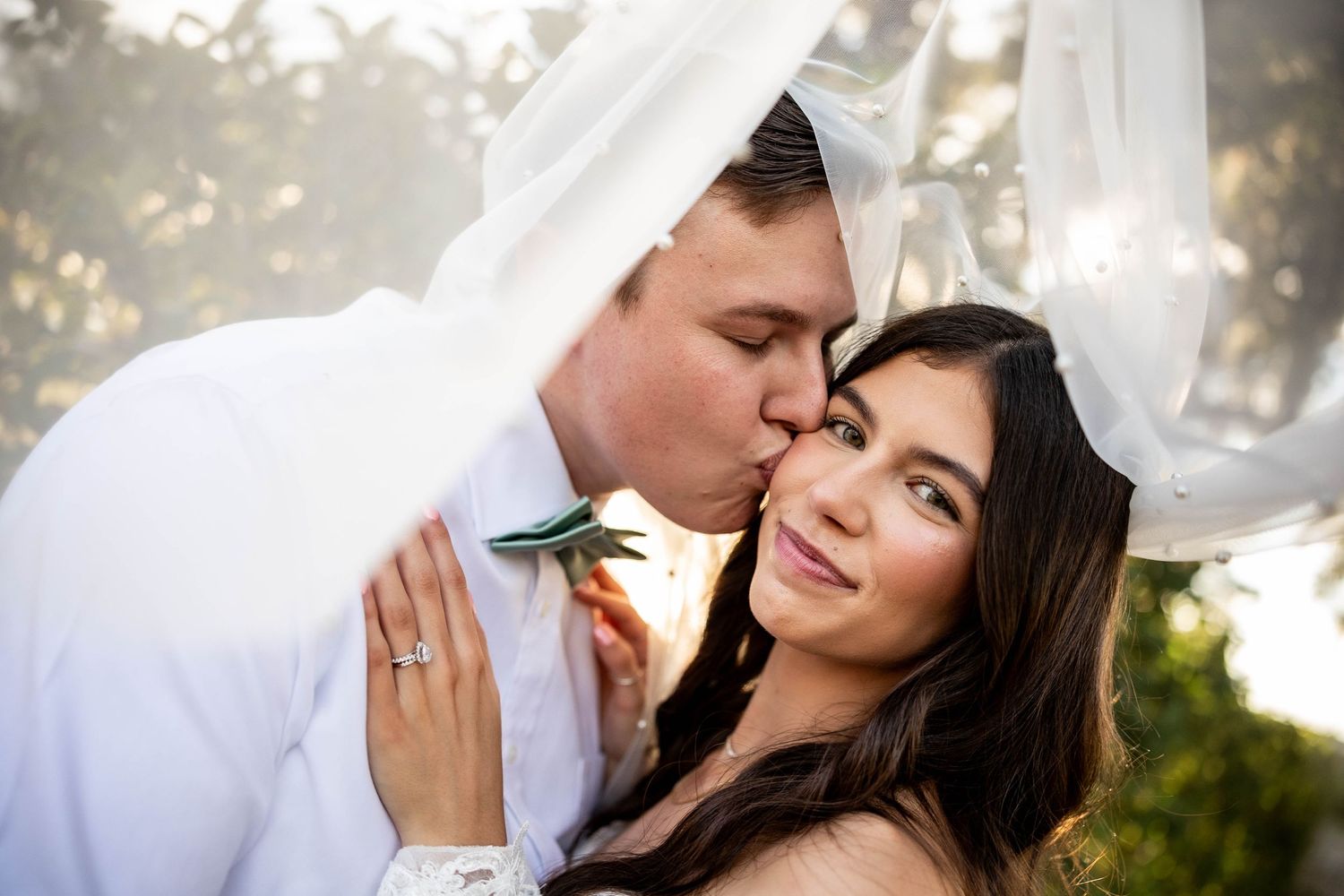 A romantic couple shares tender moments in a series of outdoor engagement photos with soft natural lighting.