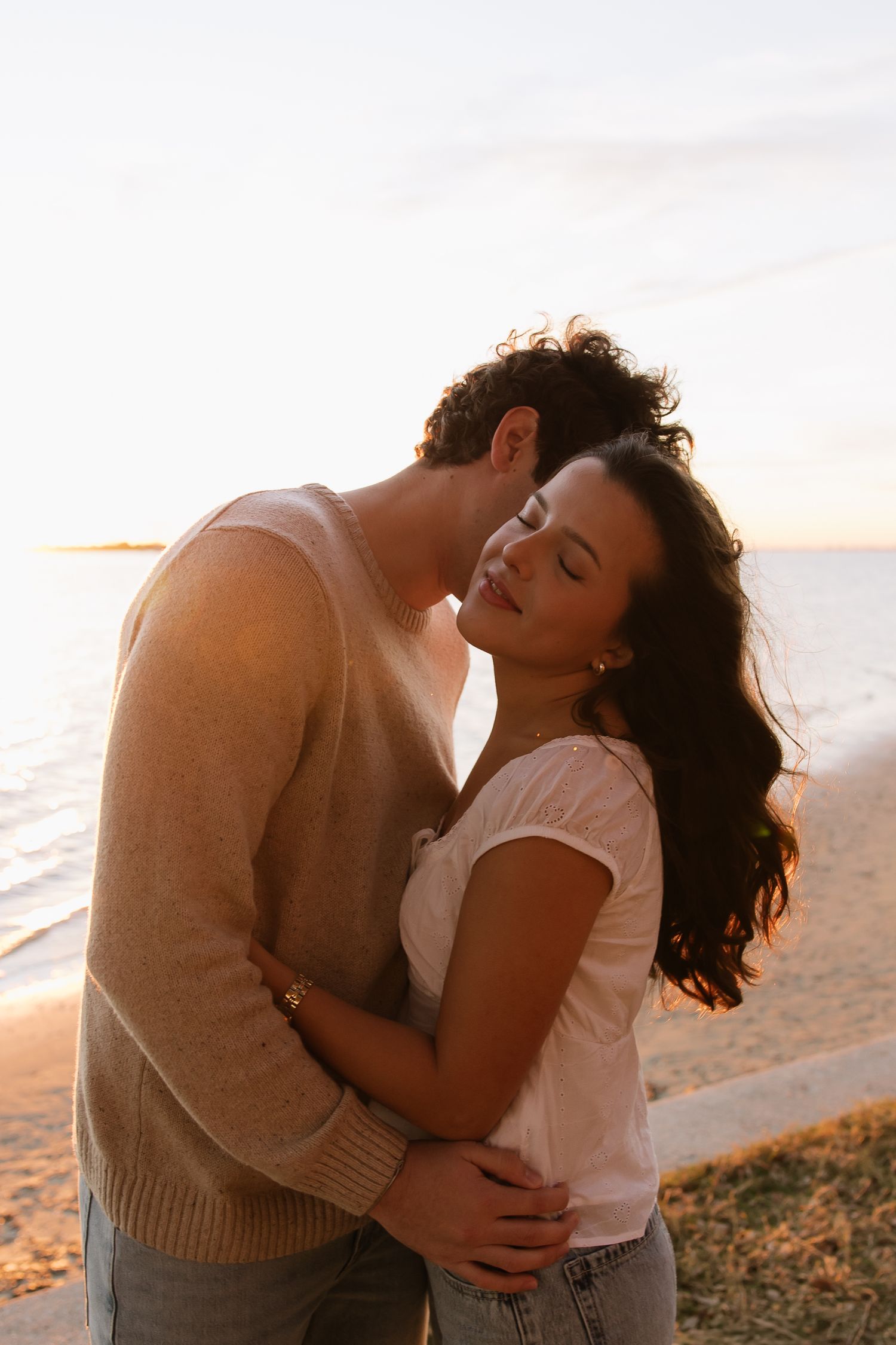 Boyfriend is kissing girlfriend's cheek at Philippe Park taken by couples photographer Michaela Gom Photography.
