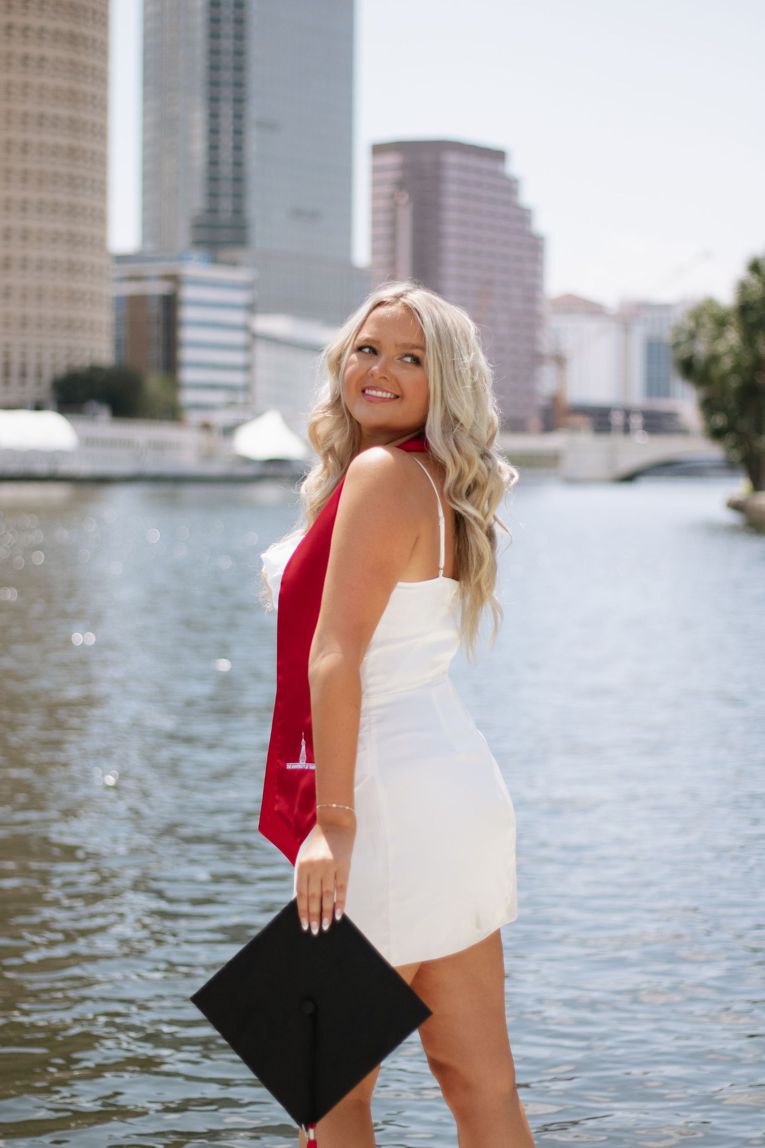 A University of Tampa grad poses for her photos holding her graduation cap taken by Tampa grad photographer Michaela Gom Photography.