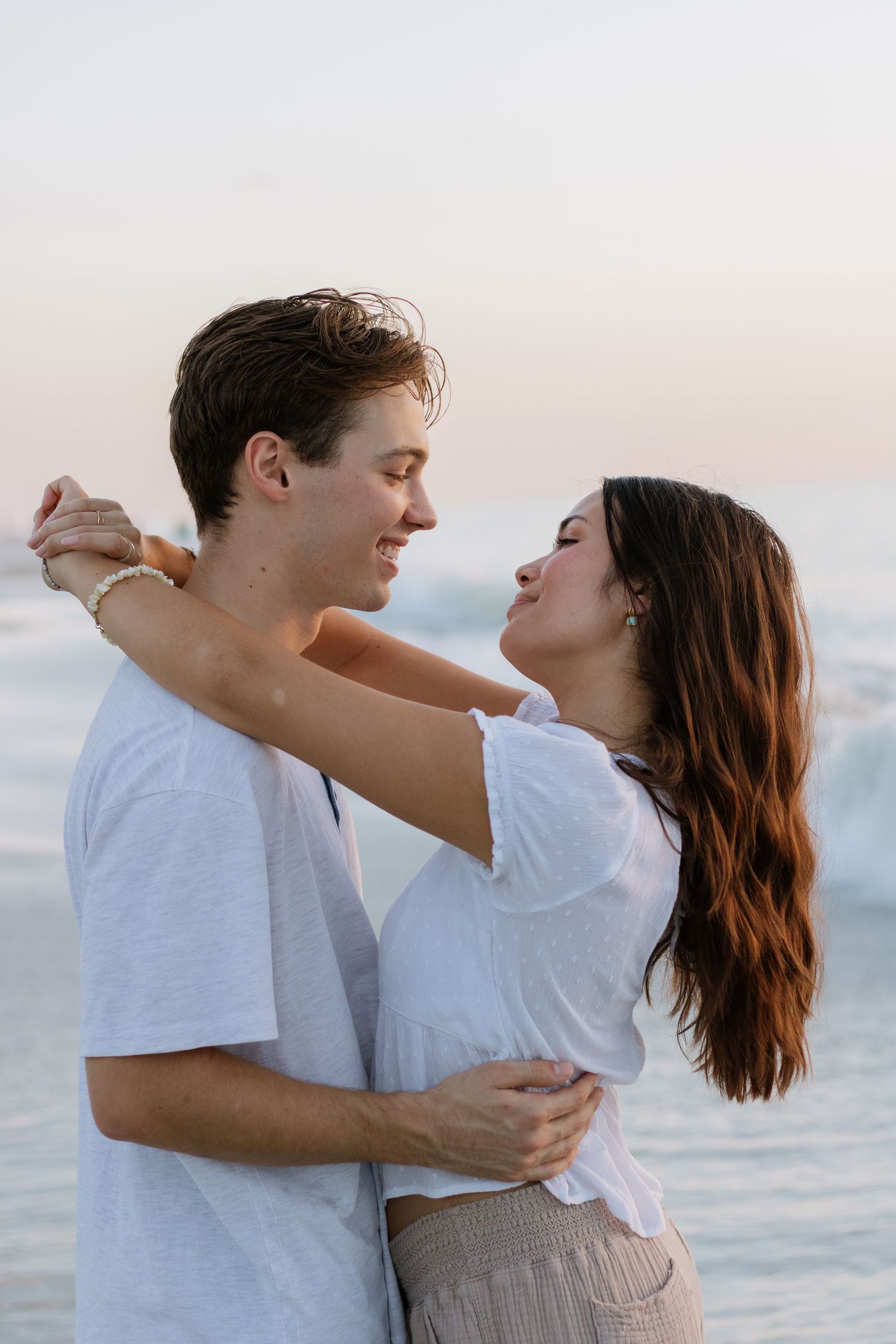 Cute couple embracing each other on Indian Rocks Beach, Florida captured by Tampa Photographer Michaela Gom Photography.