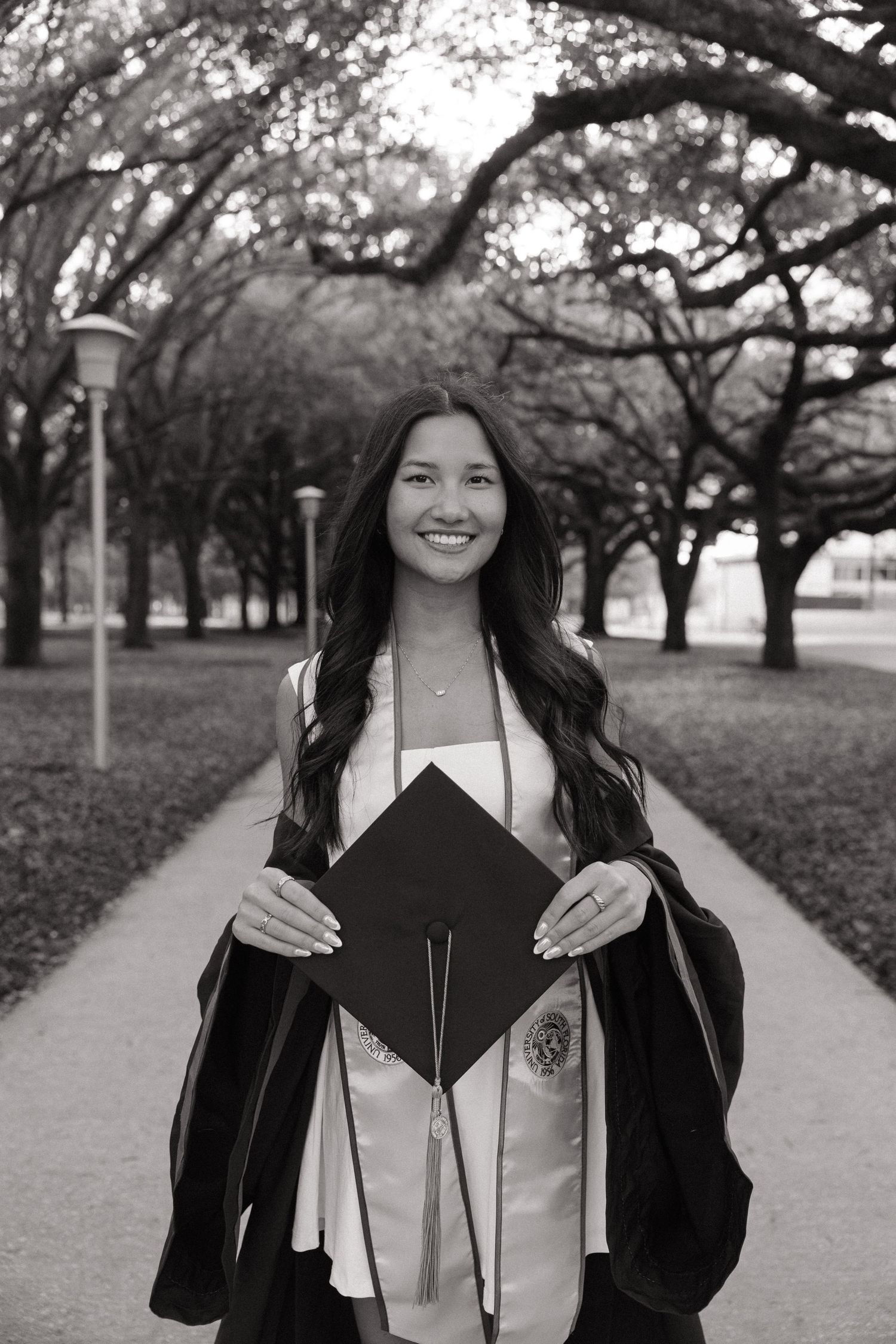 A USF grad is holding her cap for her grad photos captured by Michaela Gom Photography.