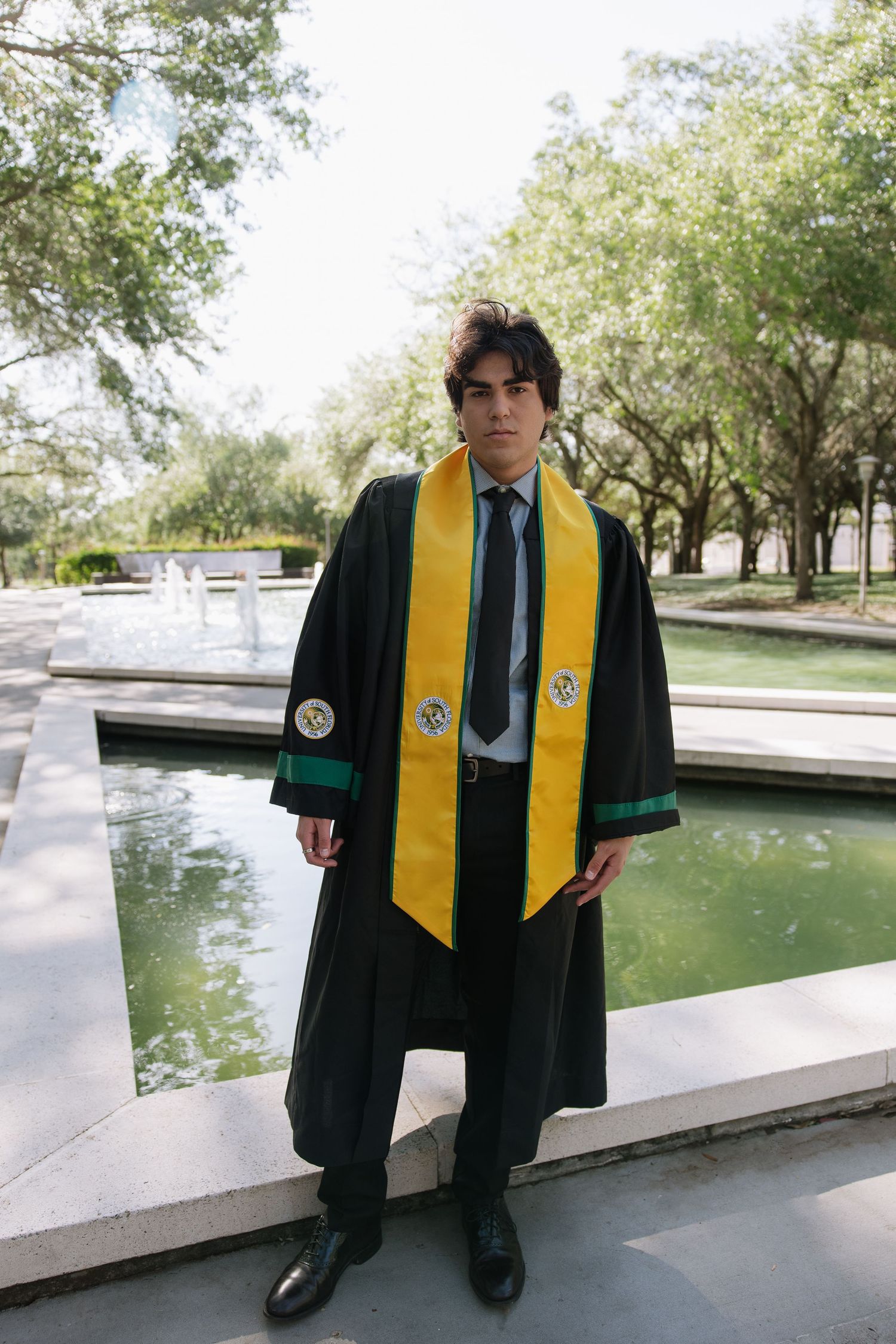USF grad stands in of the MLK plaza for his graduation photos taken by Michaela Gom Photography.