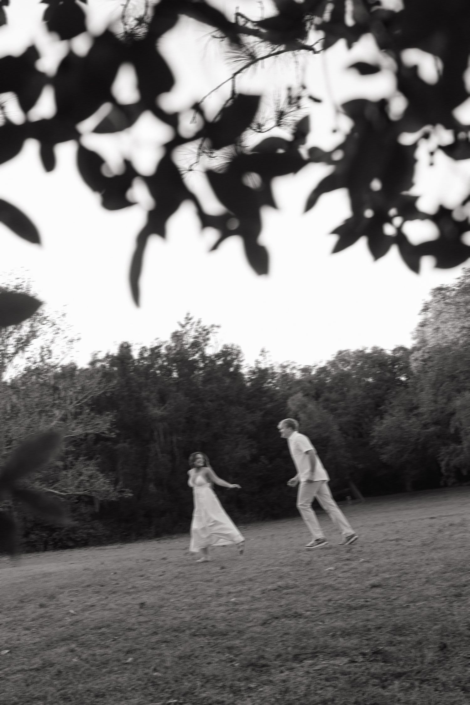 Romantic engagement photo of an engaged couple skipping at Philippe Park taken by couples photographer Michaela Gom Photography.