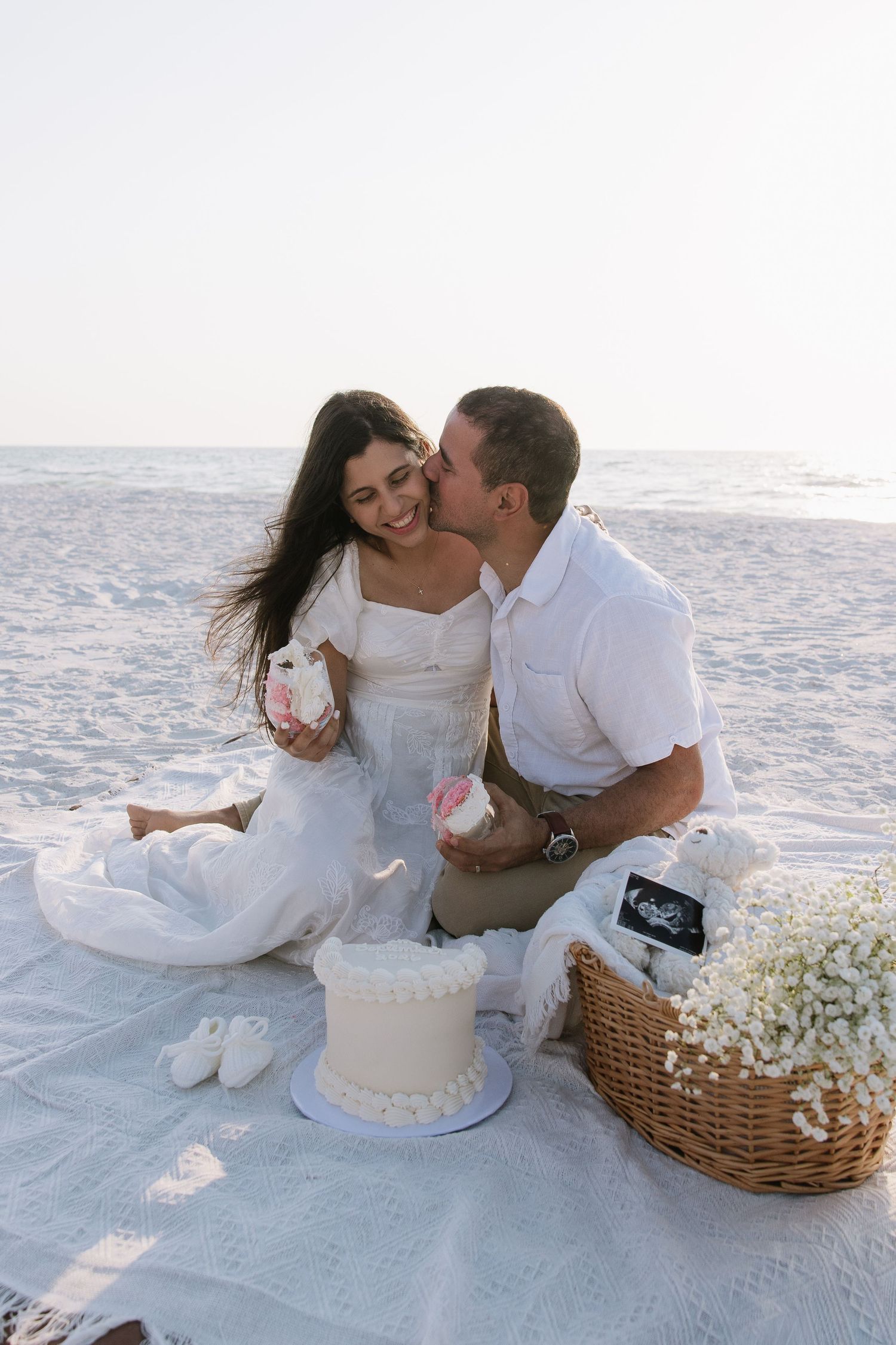 A couple is having cake for a gender reveal for their maternity photos captured by Michaela Gom Photography.
