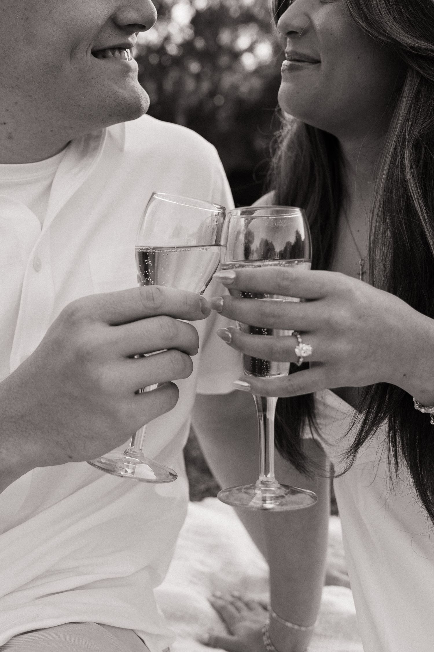 Romantic engagement photo of an engaged couple at Philippe Park holding champagne glasses captured by Michaela Gom Photography.