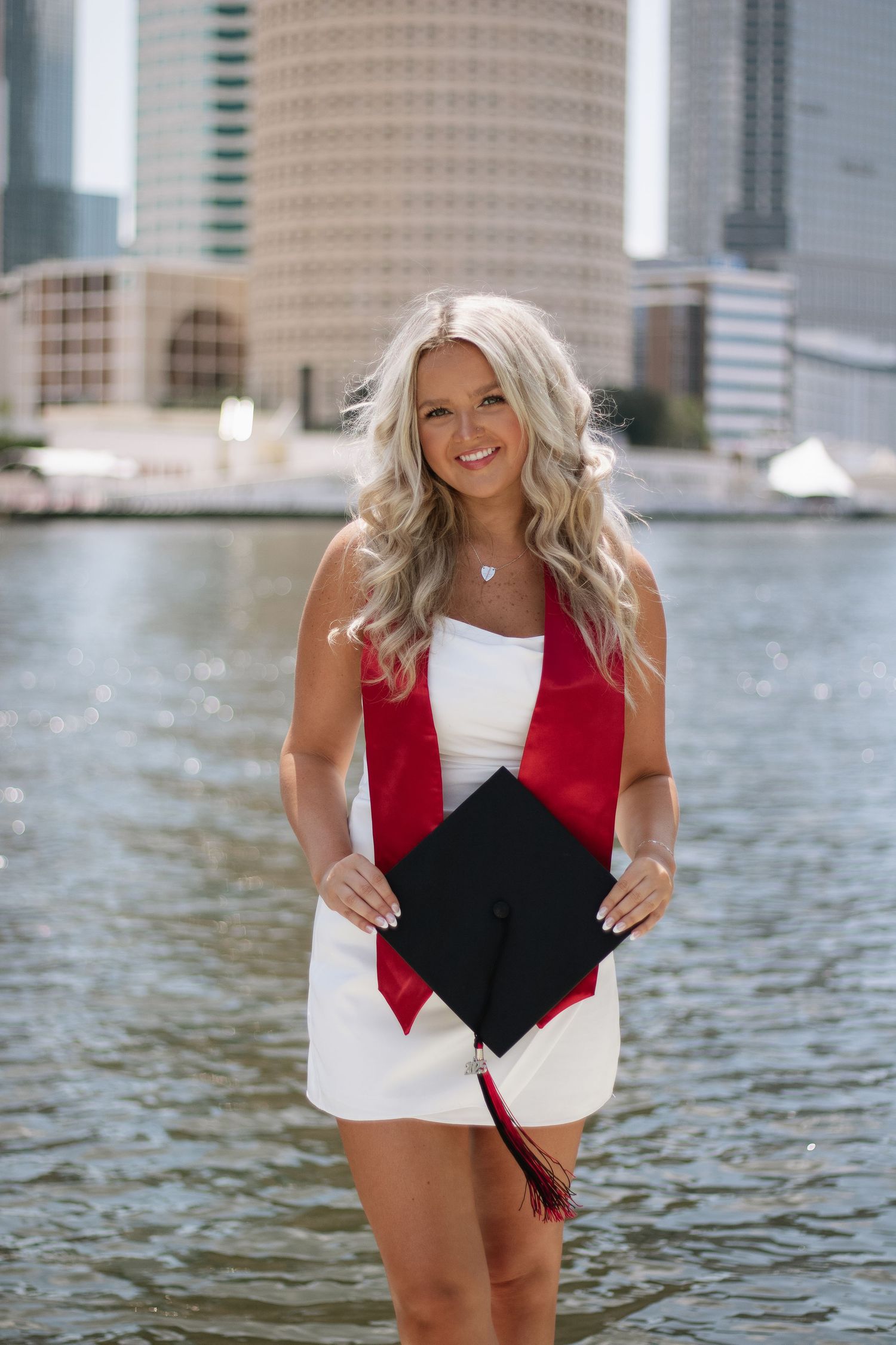 A University of Tampa graduate poses holding her graduation cap taken by Tampa grad photographer Michaela Gom Photography.