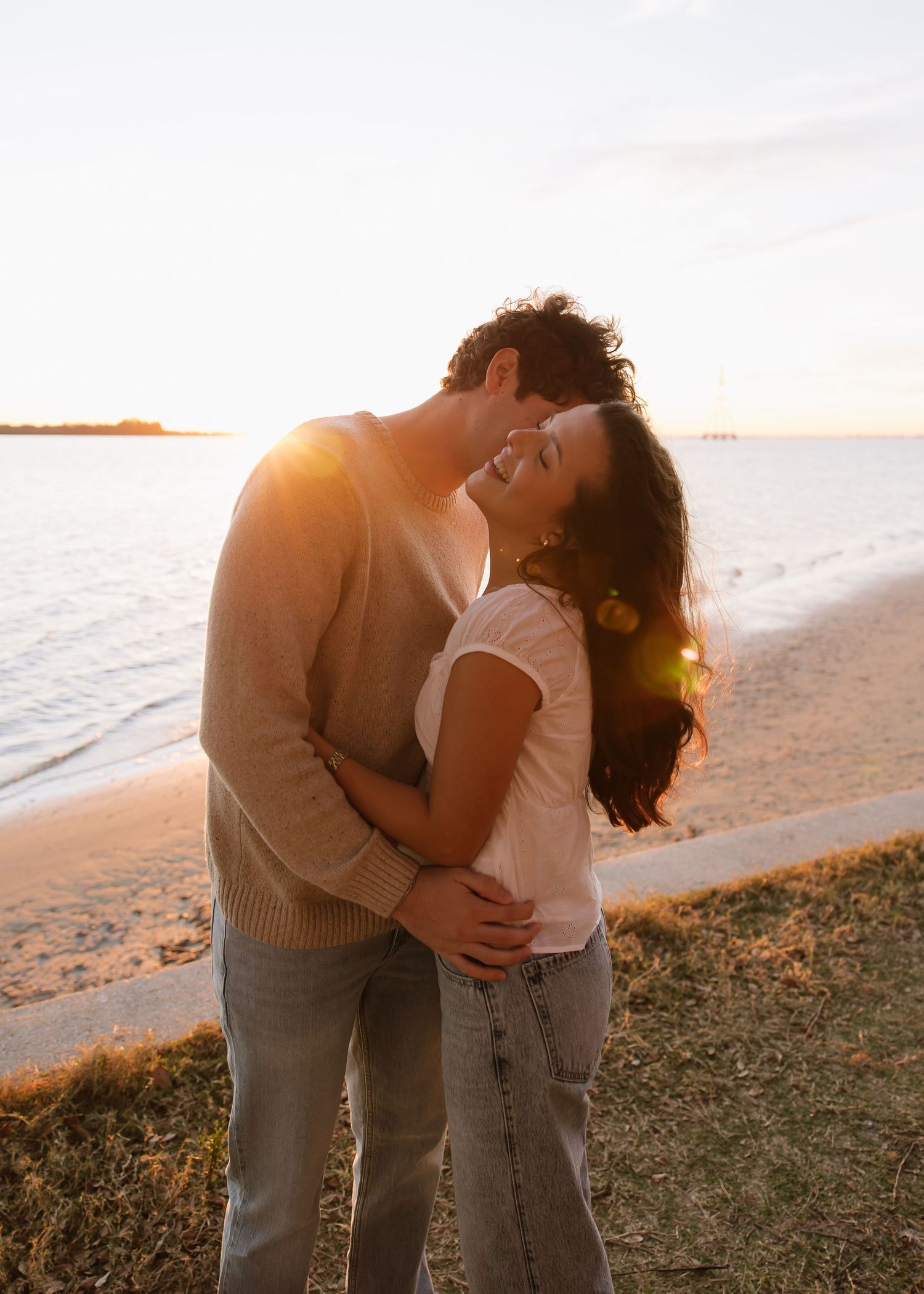 A couple from Tampa are hugging while the sunrises at Philippe park captured by Michaela Gom Photography.