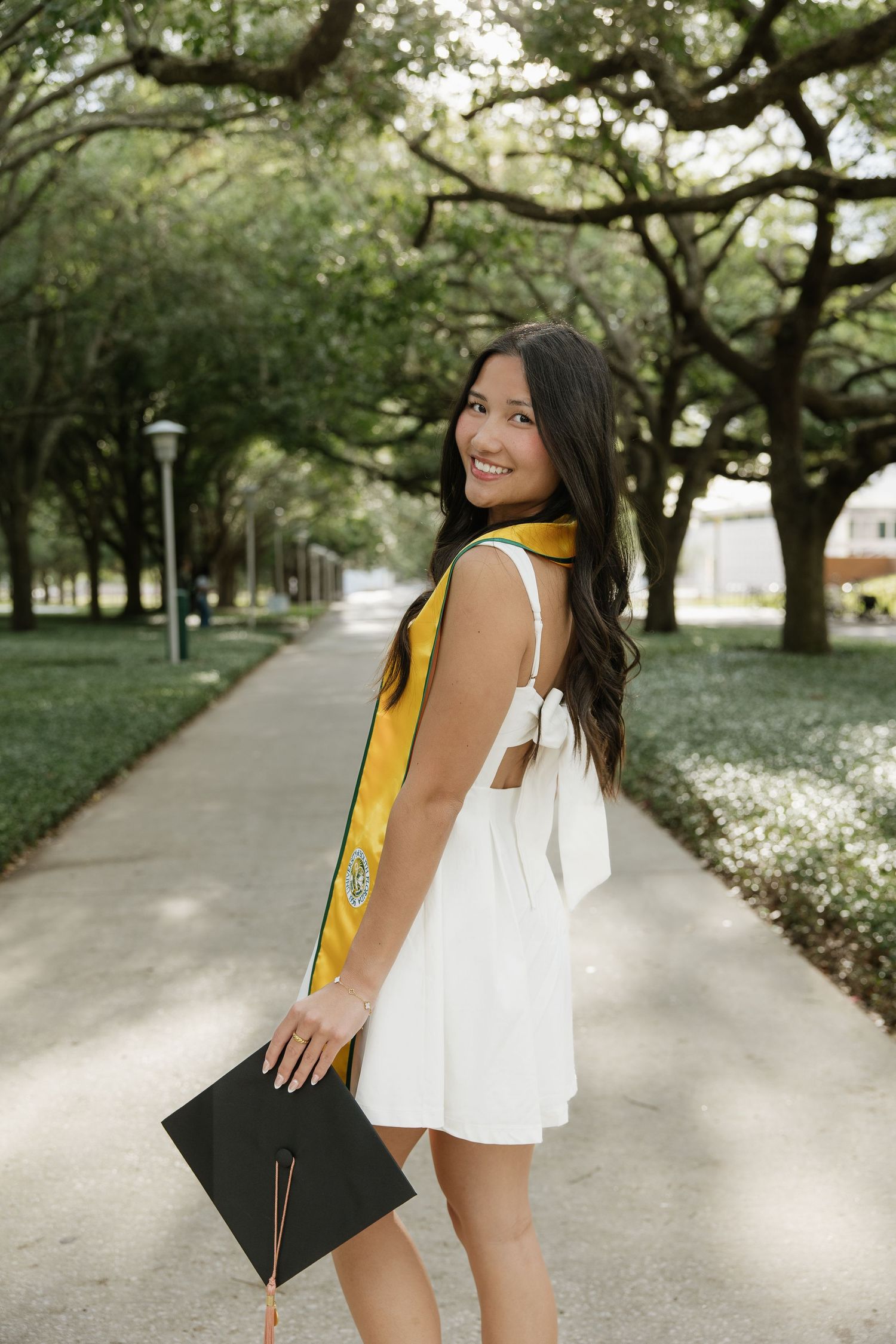 A USF grad is holding her cap for her grad photos captured by Michaela Gom Photography.