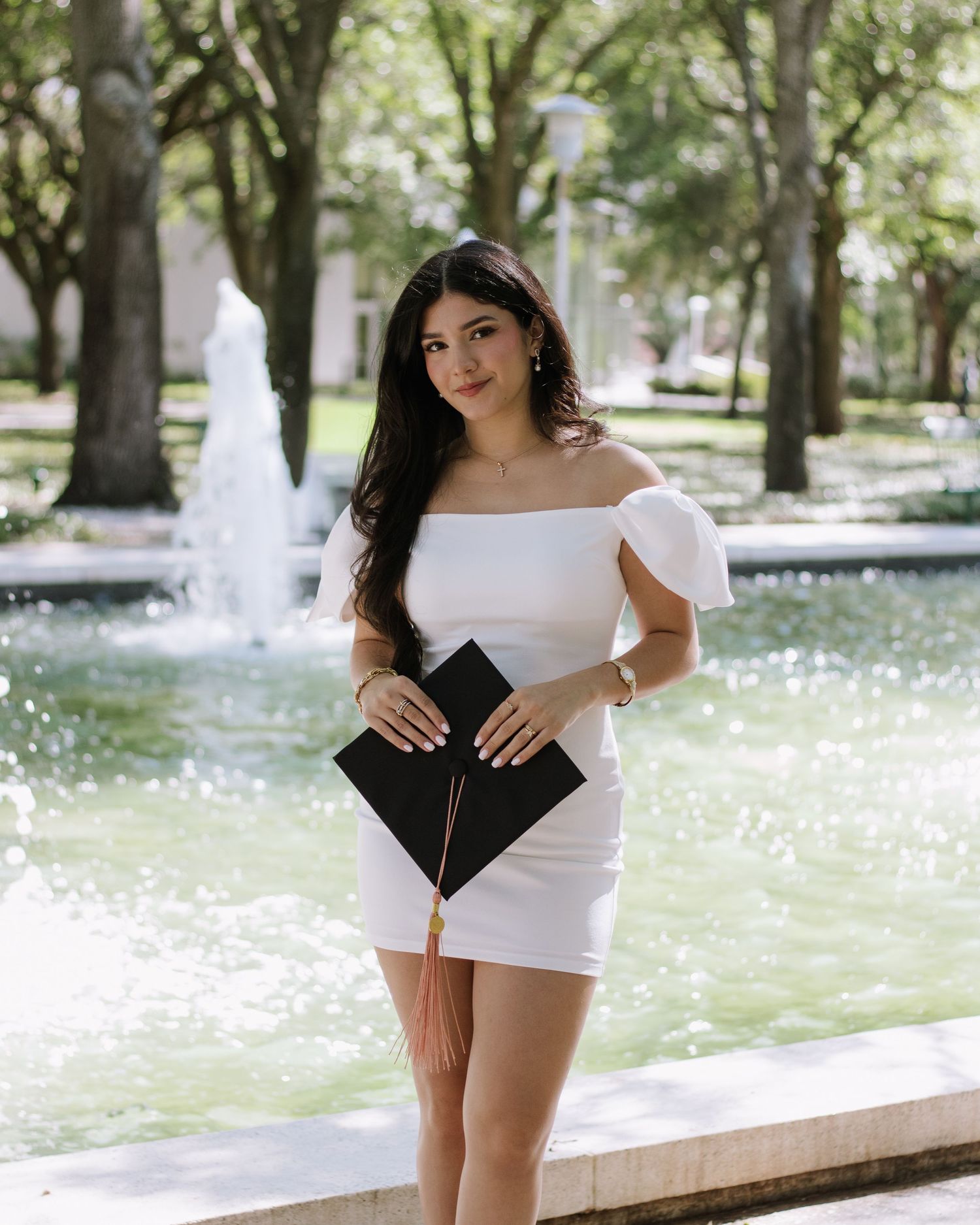 A University of South Florida graduate stands holding her cap taken by Tampa grad photographer Michaela Gom Photography.