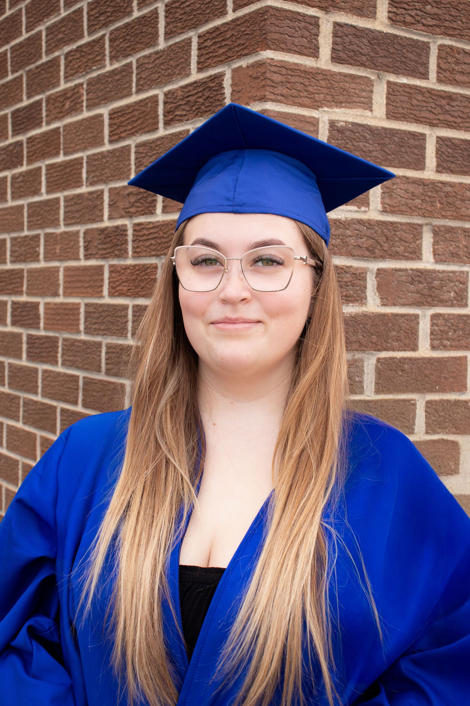 Close up portrait showing blue graduation cap and gown details.
