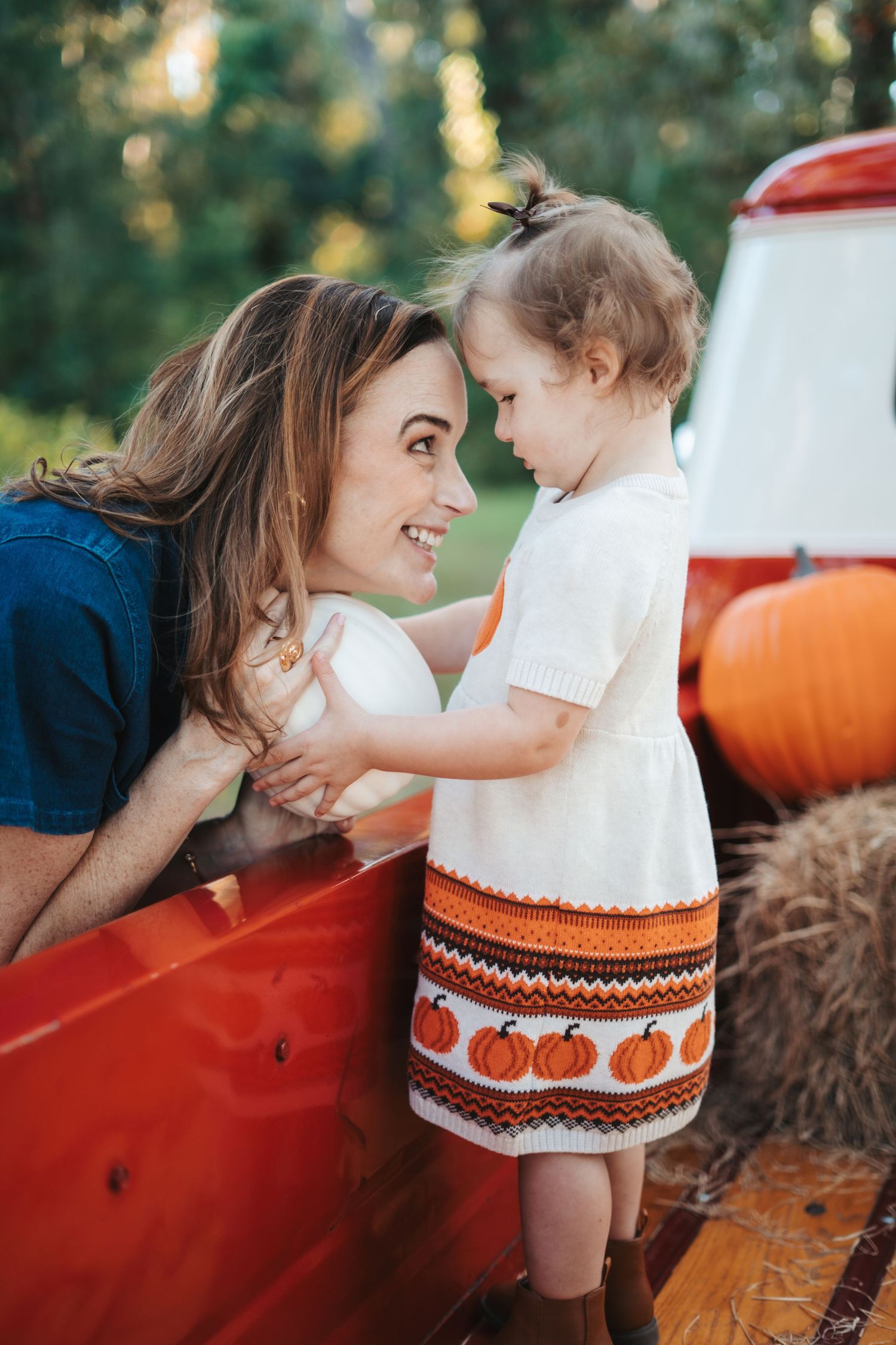 Sweet autumn scene with pumpkin-themed dress details against a red vintage truck.