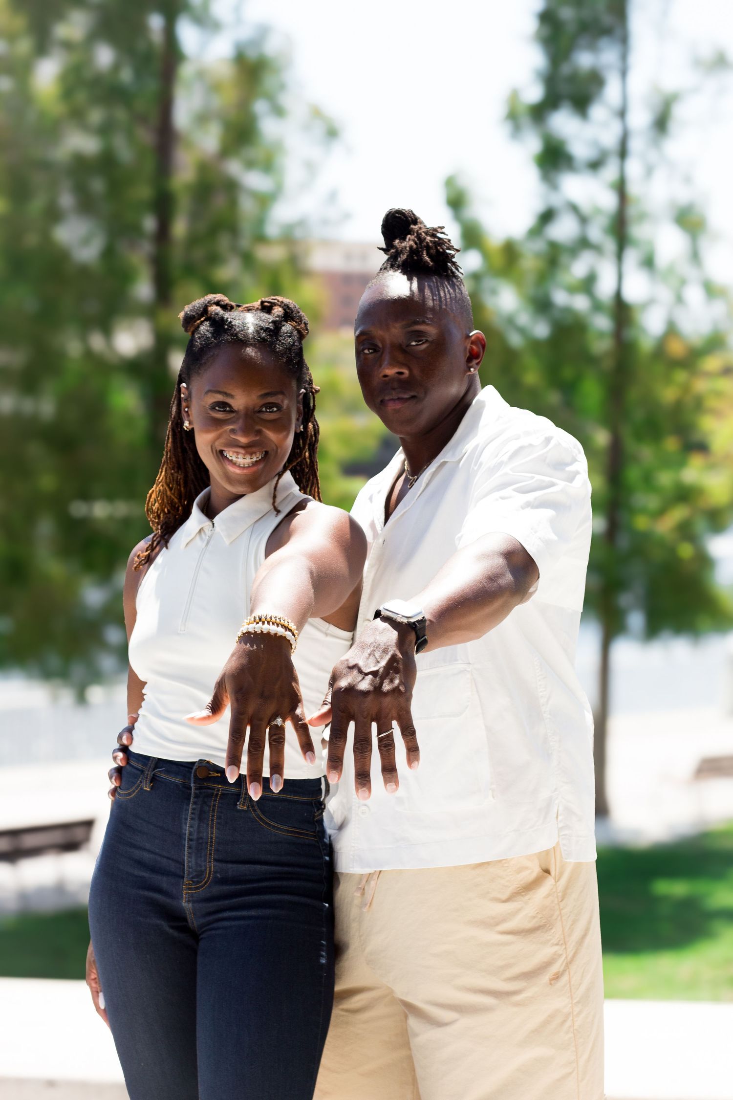 A couple laughs together while wearing coordinated white and blue casual outfits.
